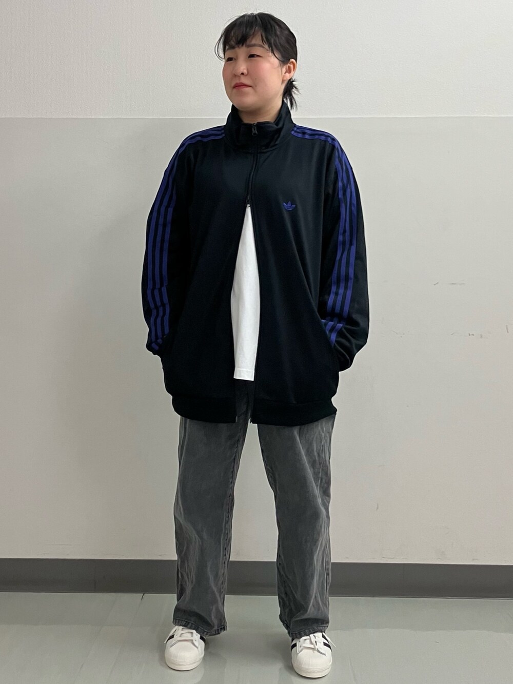 ブラック系のジャージ、ホワイト系のスニーカーを着用したレディースの春コーディネートの2枚目の写真