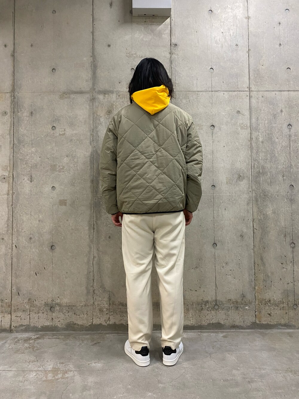 グリーン系のブルゾン、ホワイト系のその他パンツ、ホワイト系のスニーカーを着用したメンズの冬コーディネートの4枚目の写真