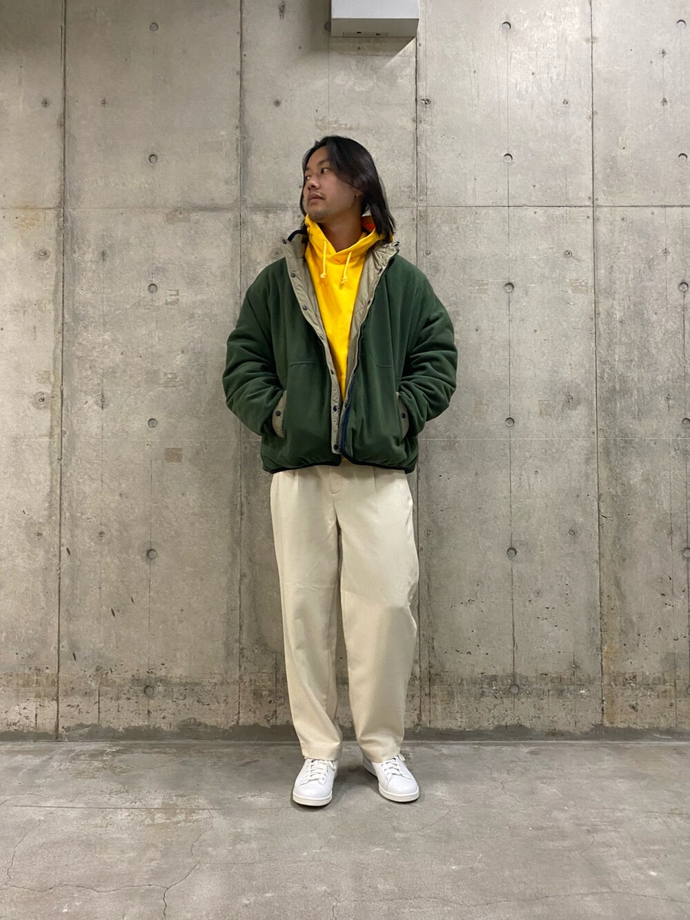 グリーン系のブルゾン、ホワイト系のその他パンツ、ホワイト系のスニーカーを着用したメンズの冬コーディネートの2枚目の写真