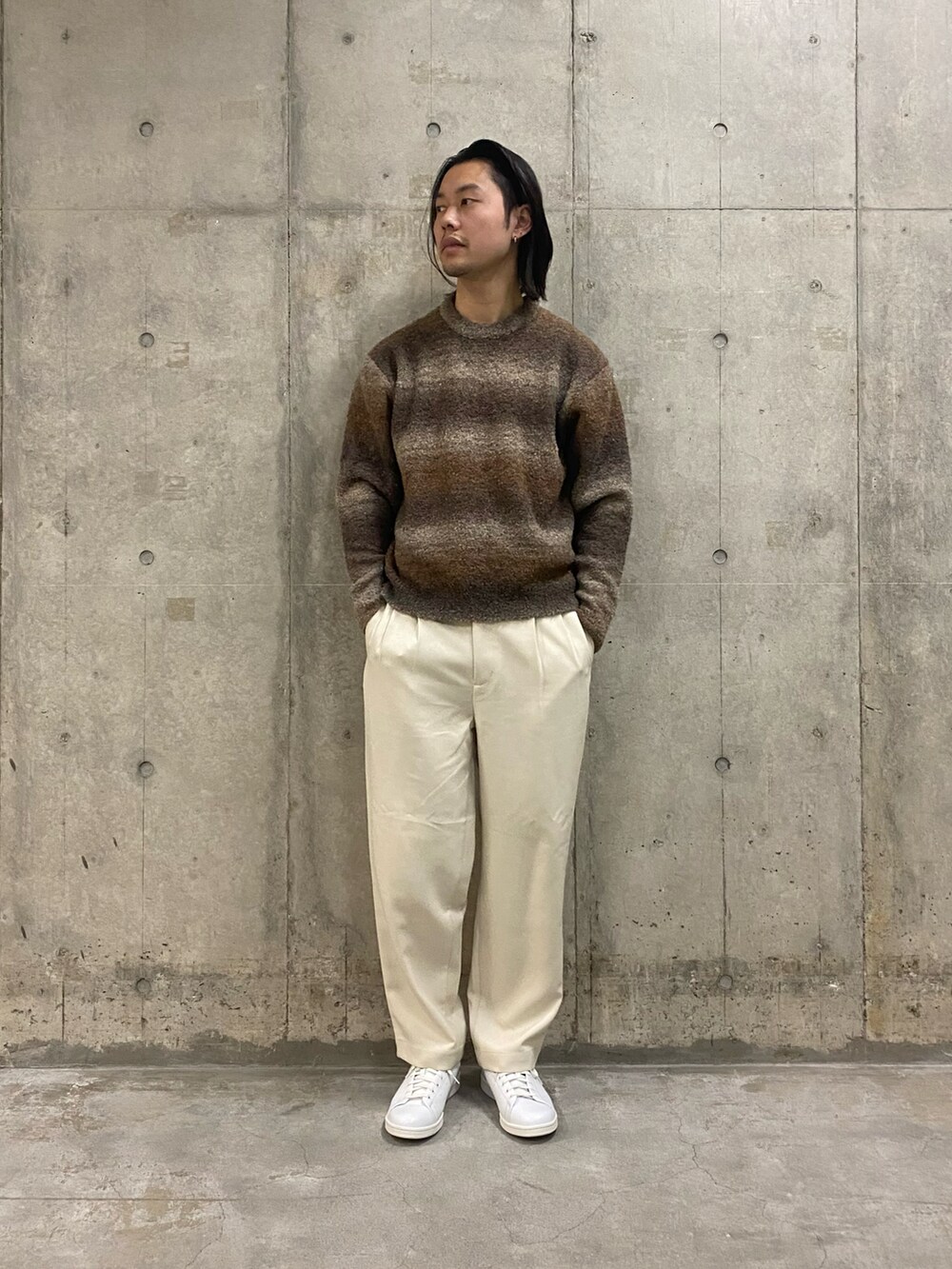 グレー系のダウンジャケット/コート、ブラウン系のニット/セーター、ホワイト系のその他パンツを着用したメンズの冬コーディネートの5枚目の写真