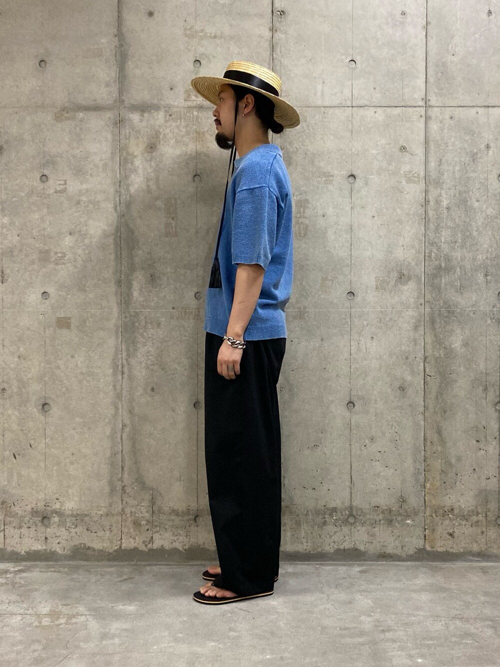 ブルー系のポロシャツ、ブラック系のサンダル、ベージュ系のハットを着用したメンズの夏コーディネートの2枚目の写真
