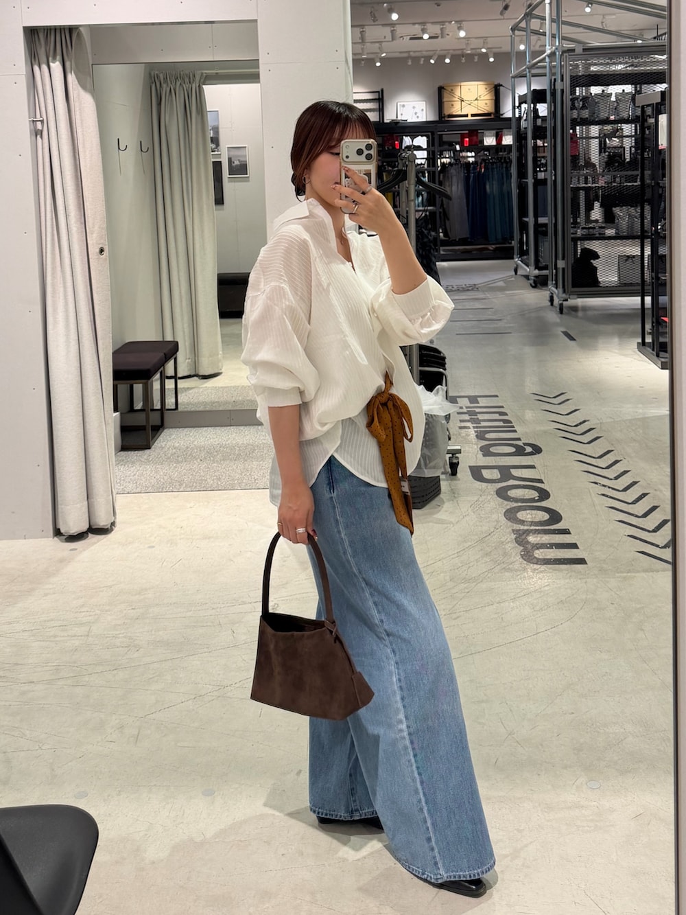 ホワイト系のシャツ/ブラウス、ブルー系のデニムパンツ、ブラウン系のトートバッグを着用したレディースの秋コーディネートの2枚目の写真