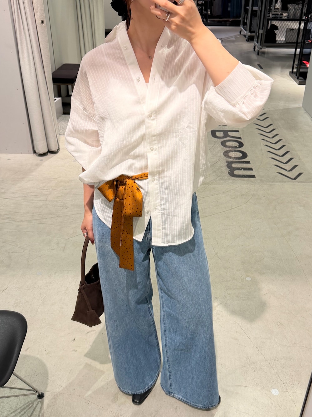 ホワイト系のシャツ/ブラウス、ブルー系のデニムパンツ、ブラウン系のトートバッグを着用したレディースの秋コーディネートの3枚目の写真