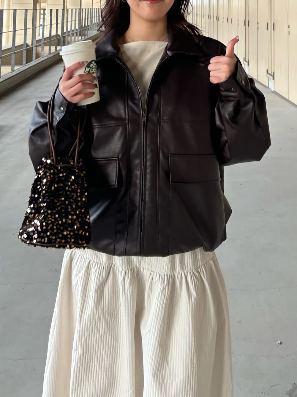 ブラウン系のブルゾン、ホワイト系のスカート、その他のショルダーバッグを着用したレディースの冬コーディネートの4枚目の写真