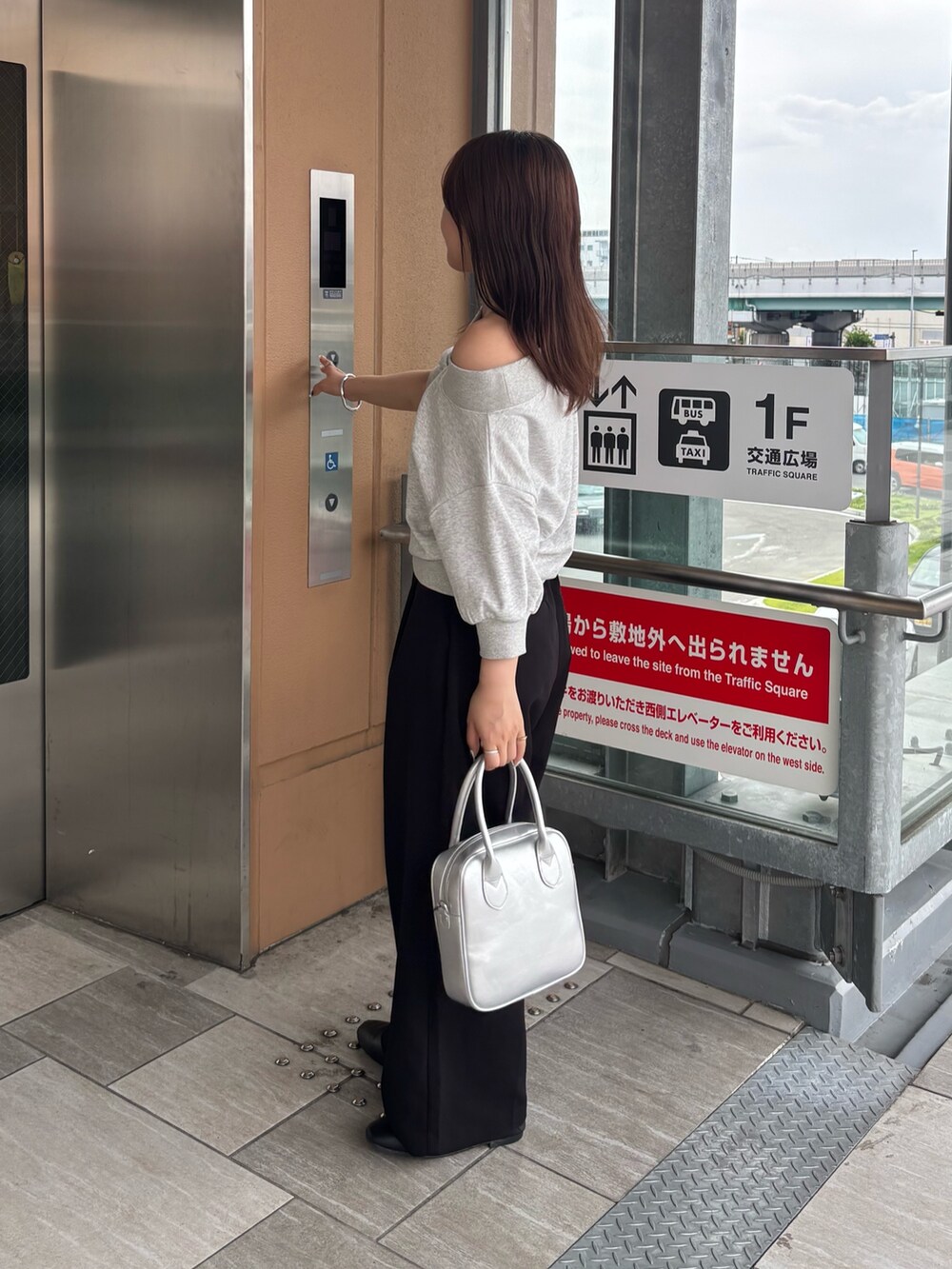 ブラック系のその他パンツ、グレー系のスウェット、シルバー系のボストンバッグを着用したレディースの夏コーディネートの2枚目の写真