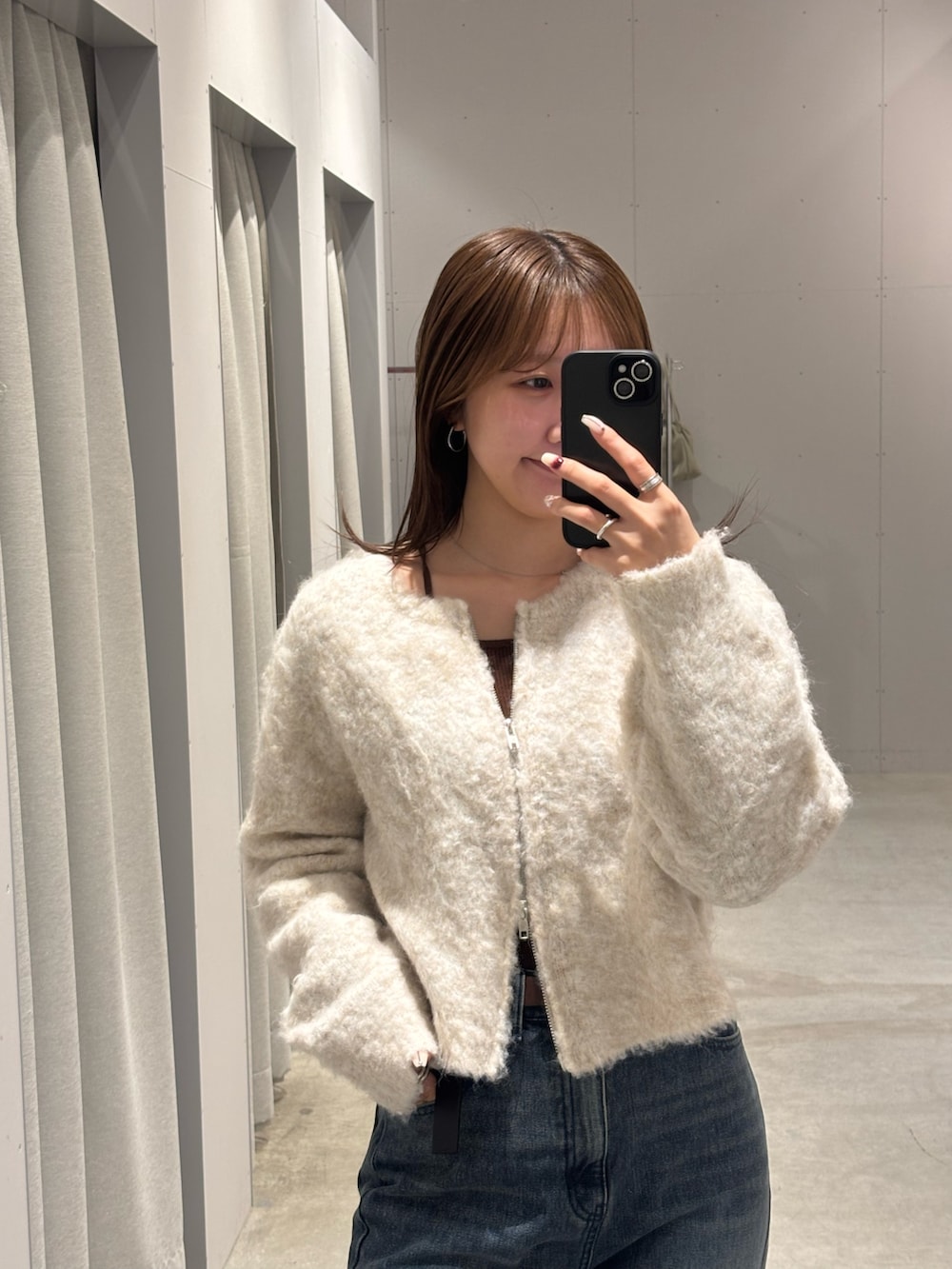 ブルー系のデニムパンツ、ホワイト系のカーディガン/ボレロ、ベージュ系のブーツを着用したレディースの冬コーディネートの2枚目の写真