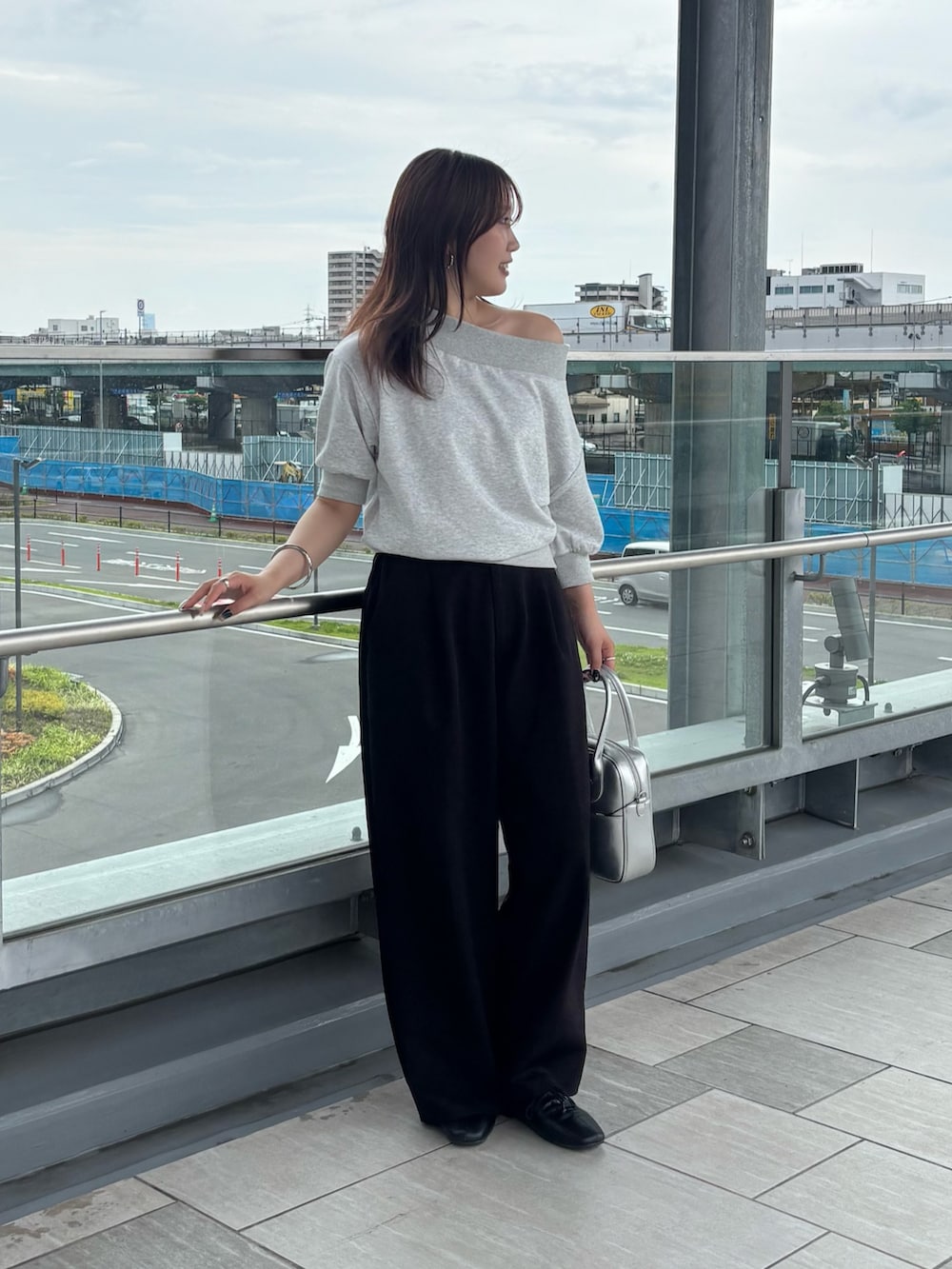 ブラック系のその他パンツ、グレー系のスウェット、シルバー系のボストンバッグを着用したレディースの夏コーディネートの3枚目の写真