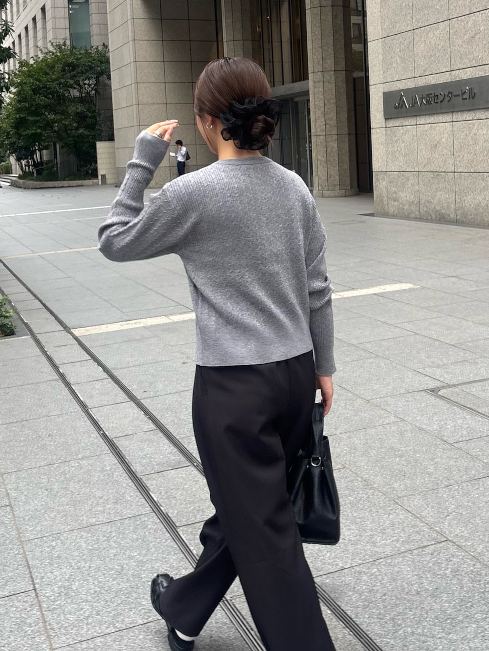 ブラック系のその他パンツ、グレー系のカーディガン/ボレロ、ブラック系のハンドバッグを着用したレディースの秋コーディネートの4枚目の写真