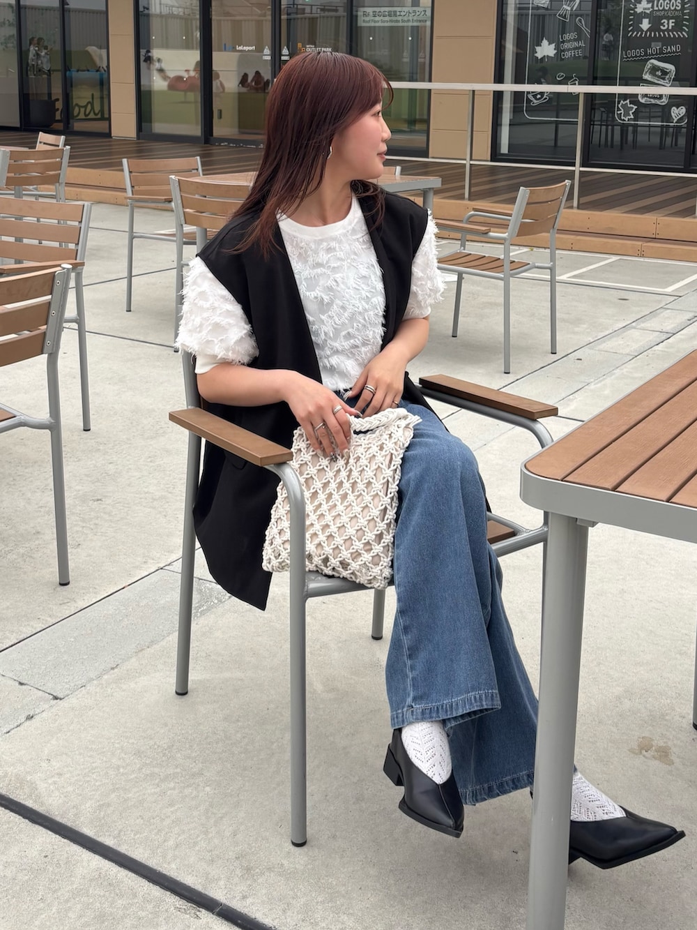 ブラック系のその他アウター、ホワイト系のシャツ/ブラウス、ブルー系のデニムパンツを着用したレディースの春コーディネートの2枚目の写真