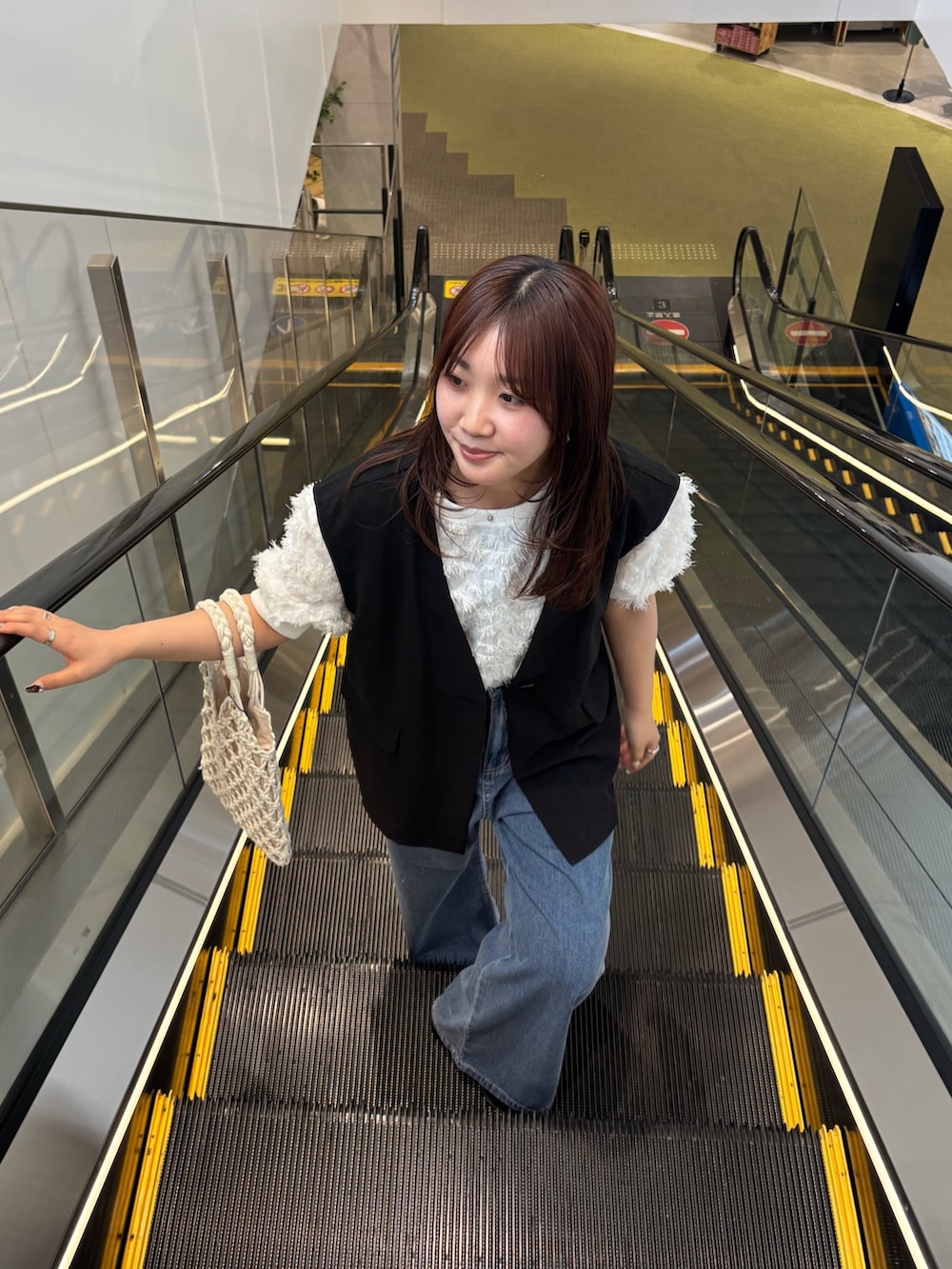 ブラック系のその他アウター、ホワイト系のシャツ/ブラウス、ブルー系のデニムパンツを着用したレディースの春コーディネートの3枚目の写真