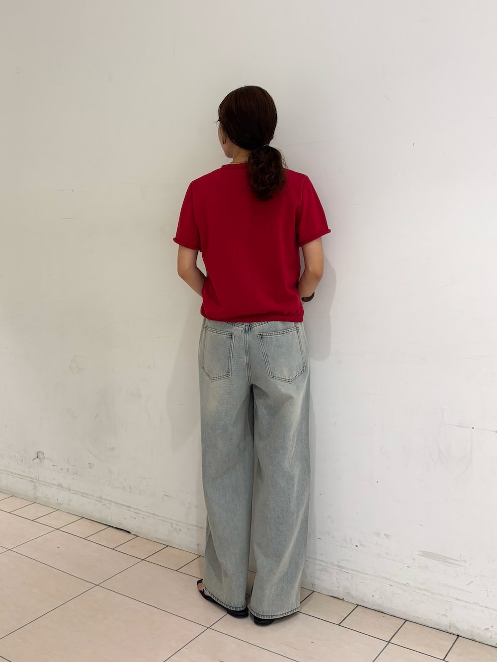 ブルー系のデニムパンツ、レッド系のカーディガン/ボレロ、ブラウン系のメガネを着用したレディースの夏コーディネートの3枚目の写真