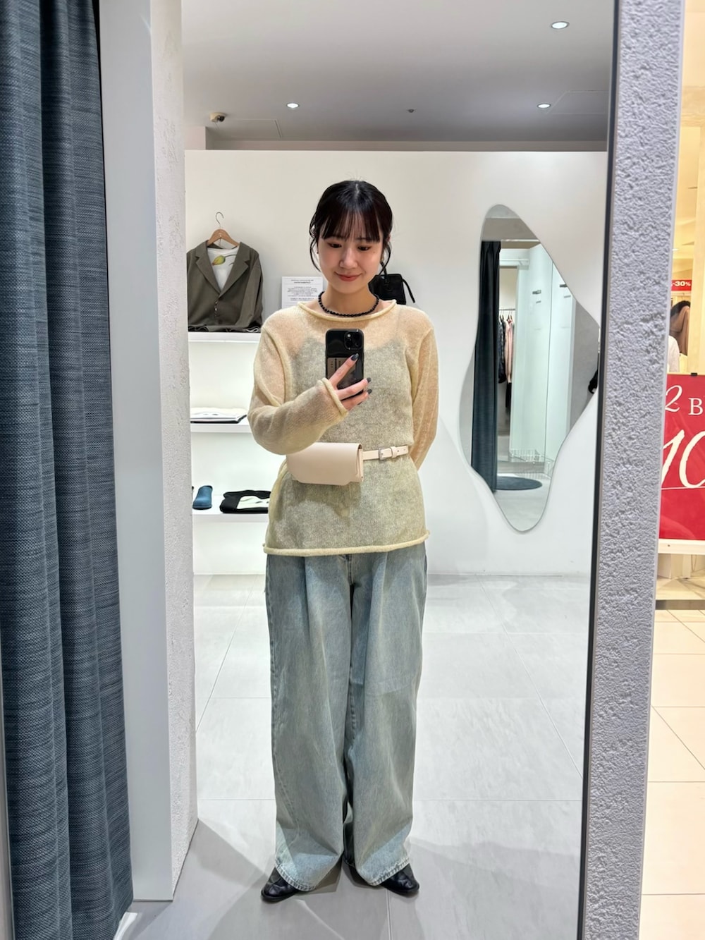 ブルー系のデニムパンツ、イエロー系のニット/セーター、ホワイト系のボディバッグ/ウエストポーチを着用したレディースの冬コーディネートの7枚目の写真