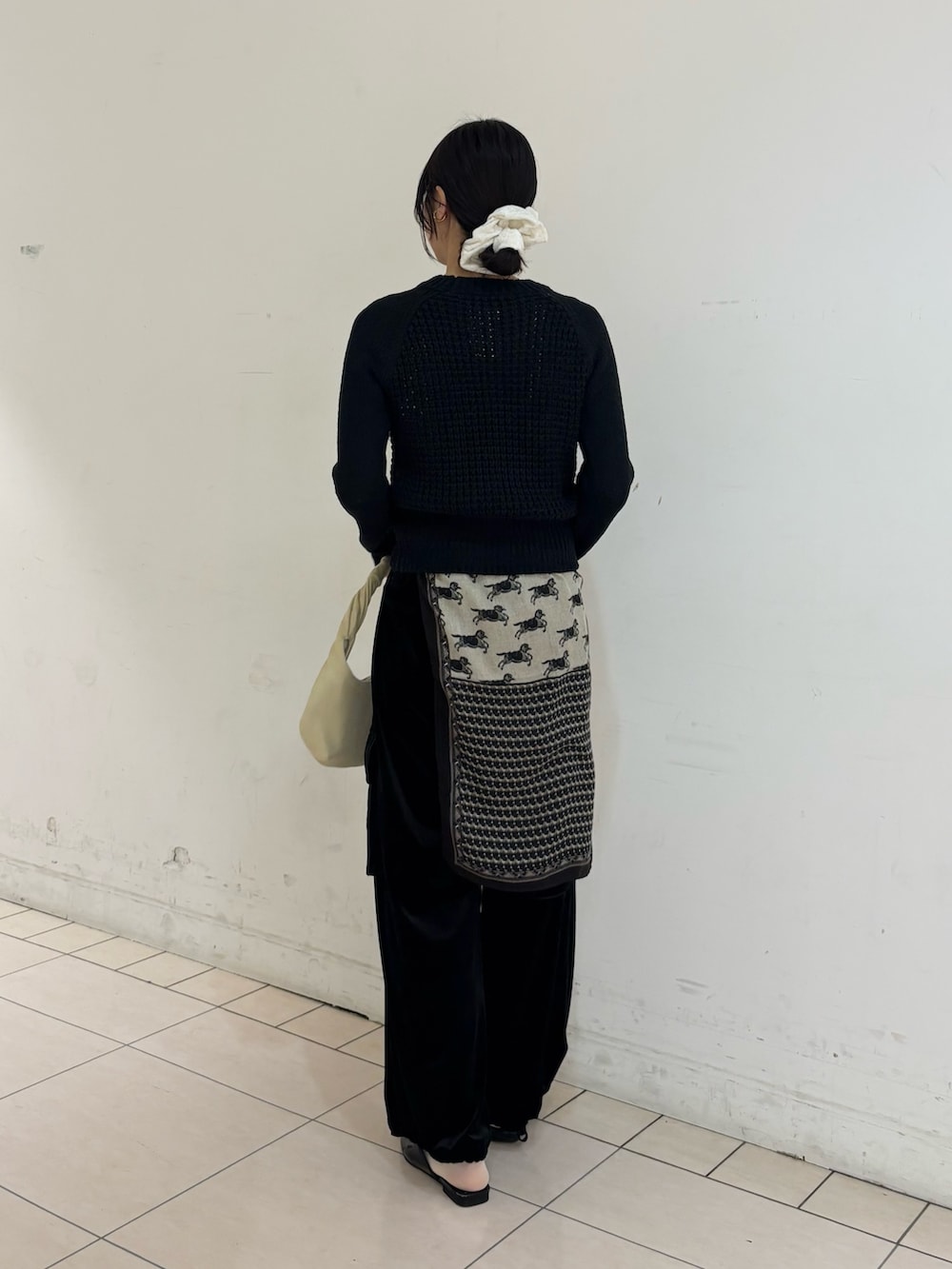 ブラック系のその他パンツ、グレー系のニット/セーター、ホワイト系のハンドバッグを着用したレディースの冬コーディネートの2枚目の写真