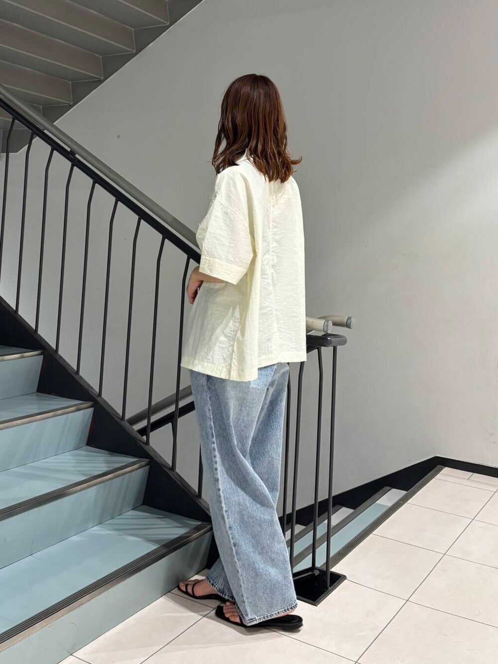 ブルー系のデニムパンツ、ホワイト系のシャツ/ブラウスを着用したレディースの夏コーディネートの2枚目の写真