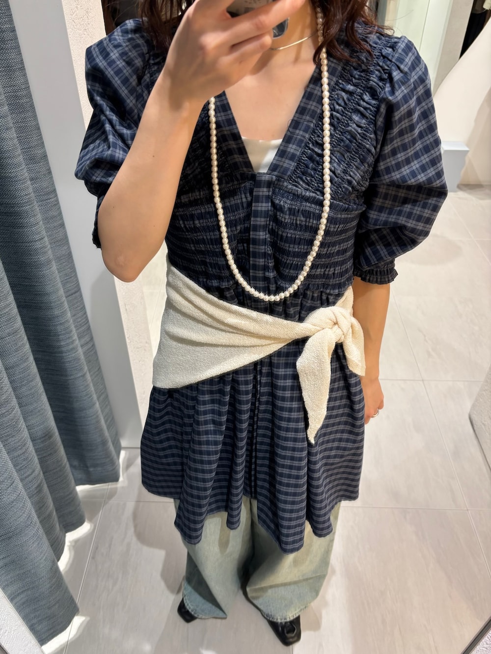 ブルー系のデニムパンツ、ブルー系のワンピース、ブラック系のその他シューズを着用したレディースの春コーディネートの4枚目の写真