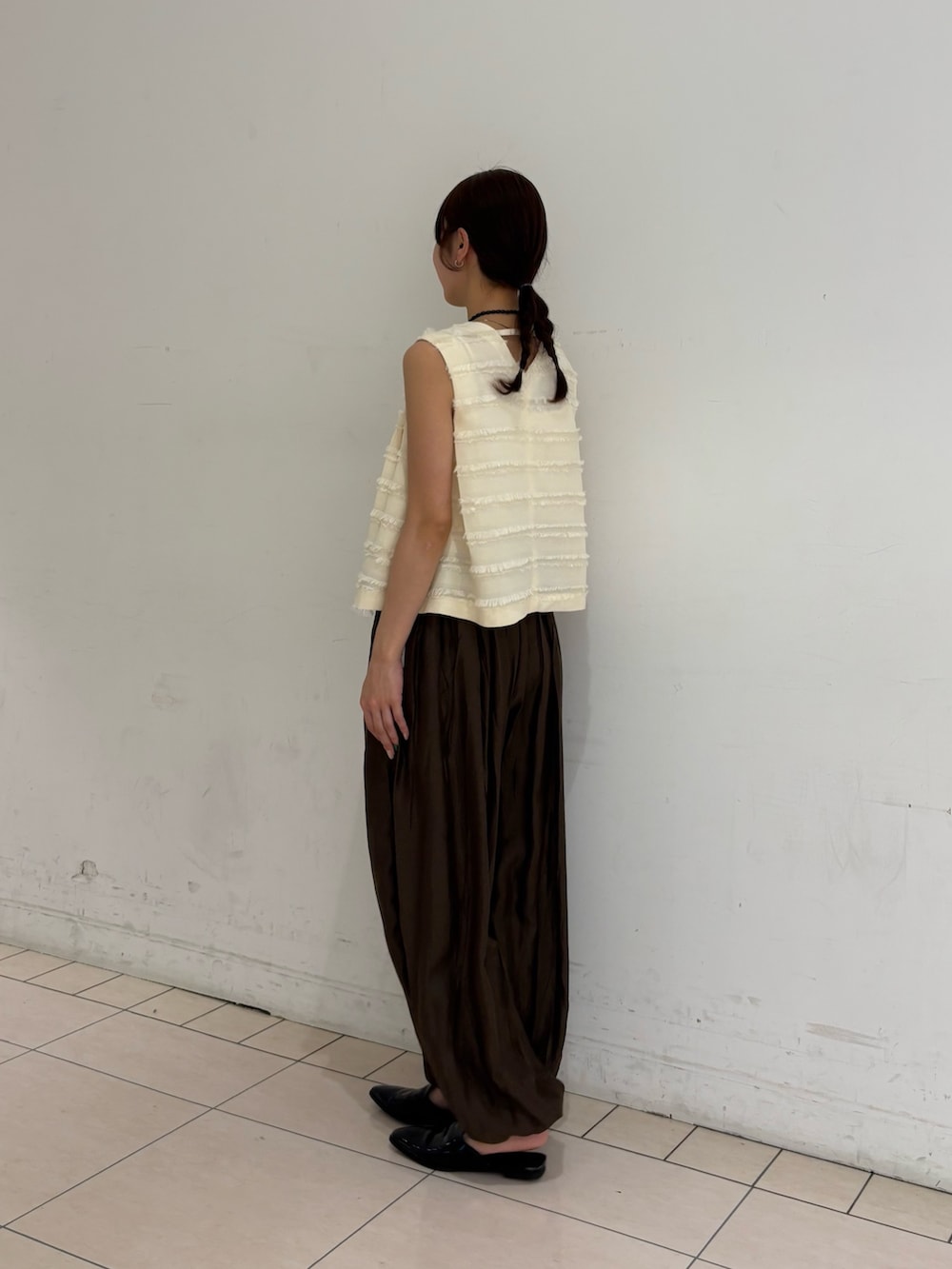 ブラウン系のその他パンツ、ホワイト系のベストを着用したレディースの春コーディネートの3枚目の写真