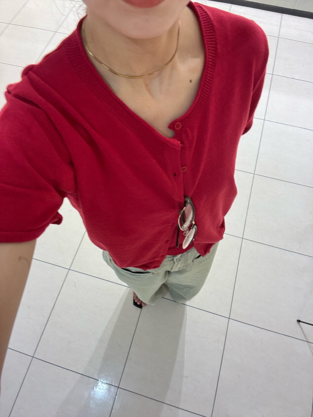 ブルー系のデニムパンツ、レッド系のカーディガン/ボレロ、ブラウン系のメガネを着用したレディースの夏コーディネートの4枚目の写真