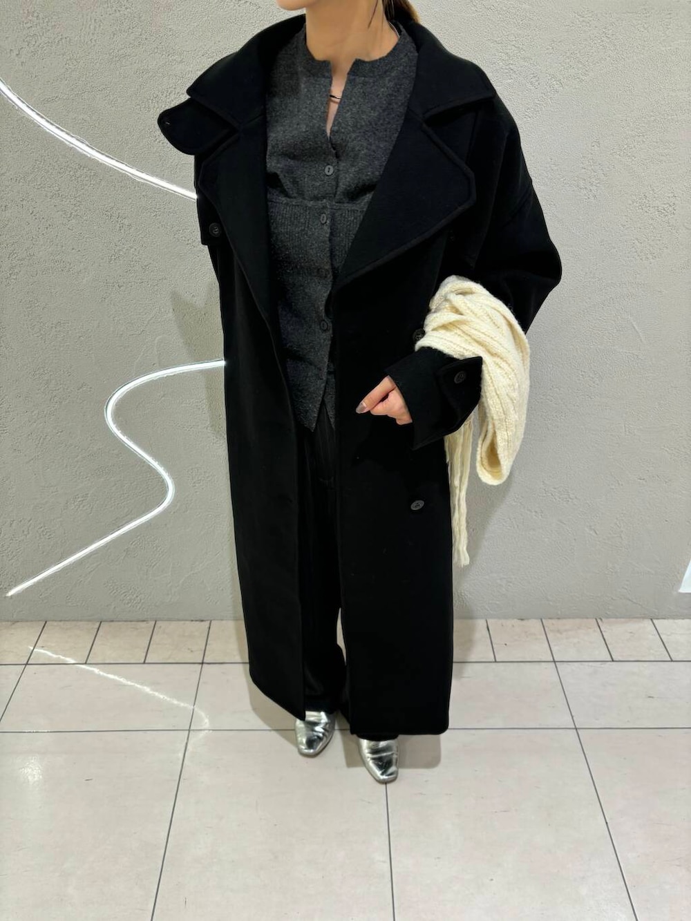 ブラック系のステンカラーコート、グレー系のその他パンツ、グレー系のカーディガン/ボレロを着用したレディースの秋コーディネートの2枚目の写真