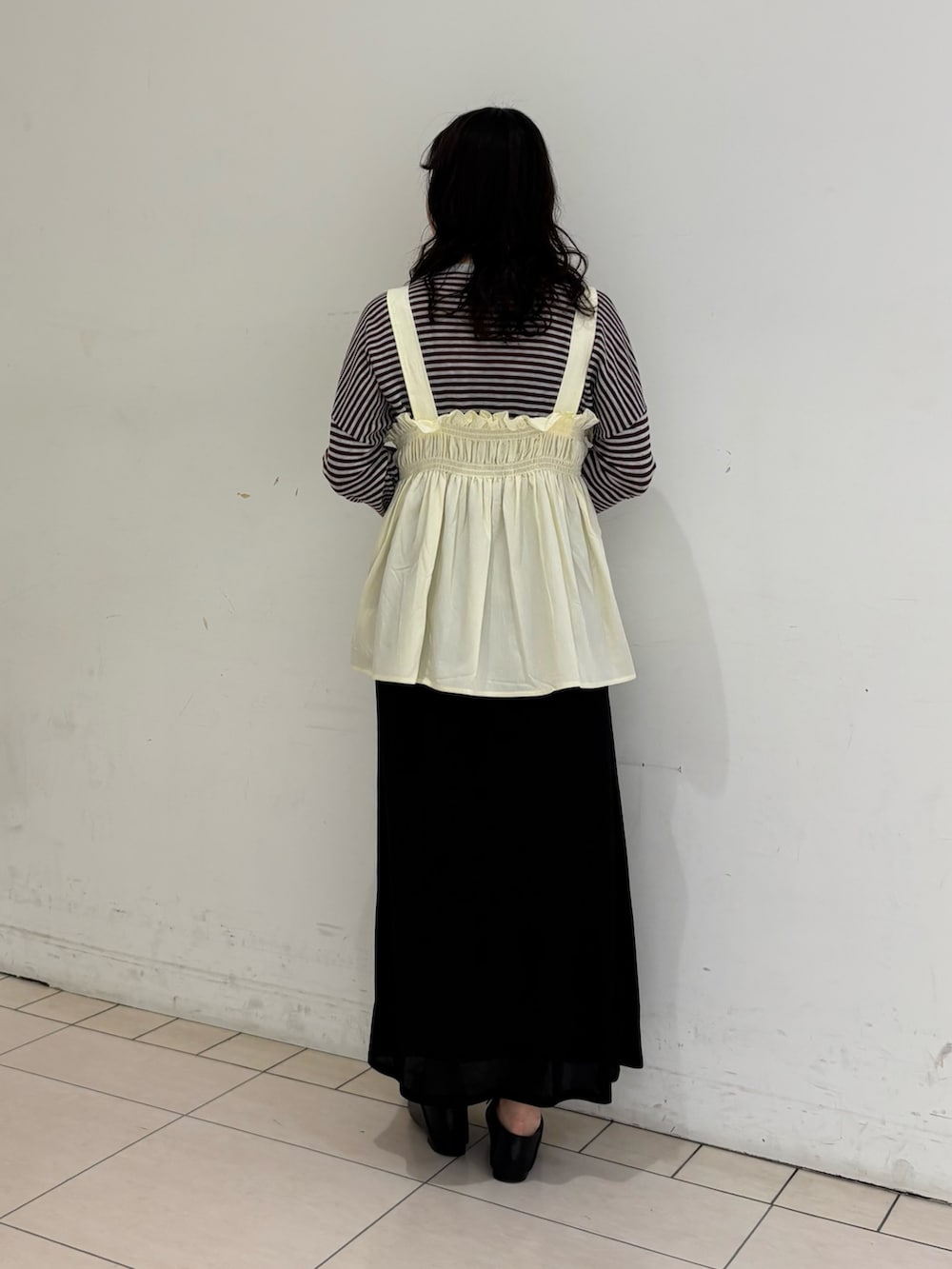 ブラック系のスカート、レッド系のニット/セーター、ホワイト系のその他トップスを着用したレディースの春コーディネートの4枚目の写真