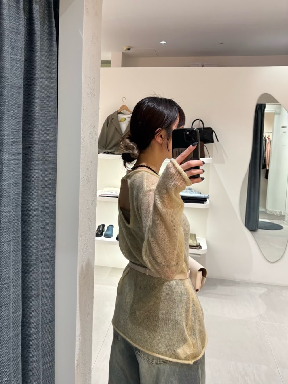 ブルー系のデニムパンツ、イエロー系のニット/セーター、ホワイト系のボディバッグ/ウエストポーチを着用したレディースの冬コーディネートの6枚目の写真