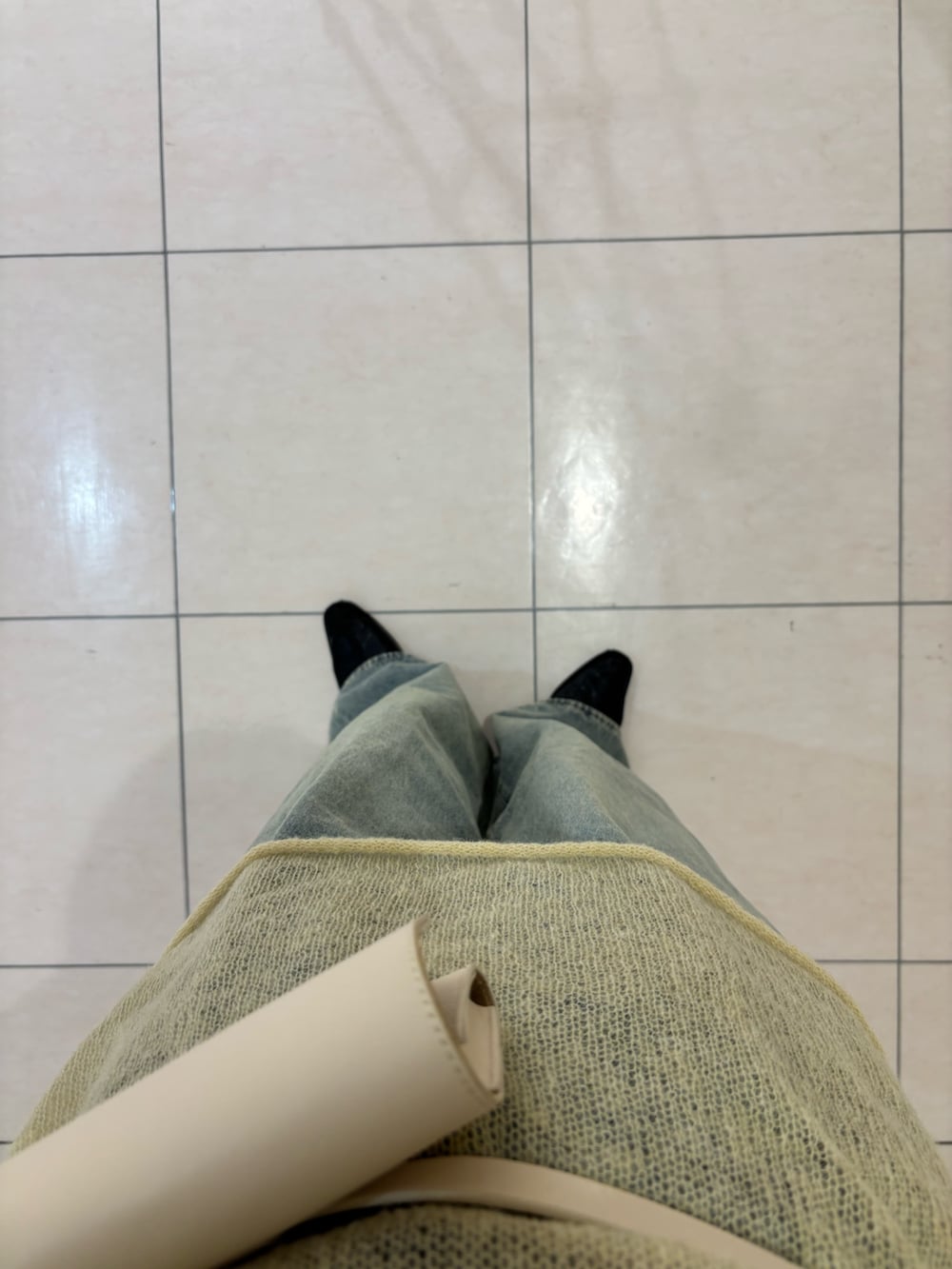 ブルー系のデニムパンツ、イエロー系のニット/セーター、ホワイト系のボディバッグ/ウエストポーチを着用したレディースの冬コーディネートの4枚目の写真