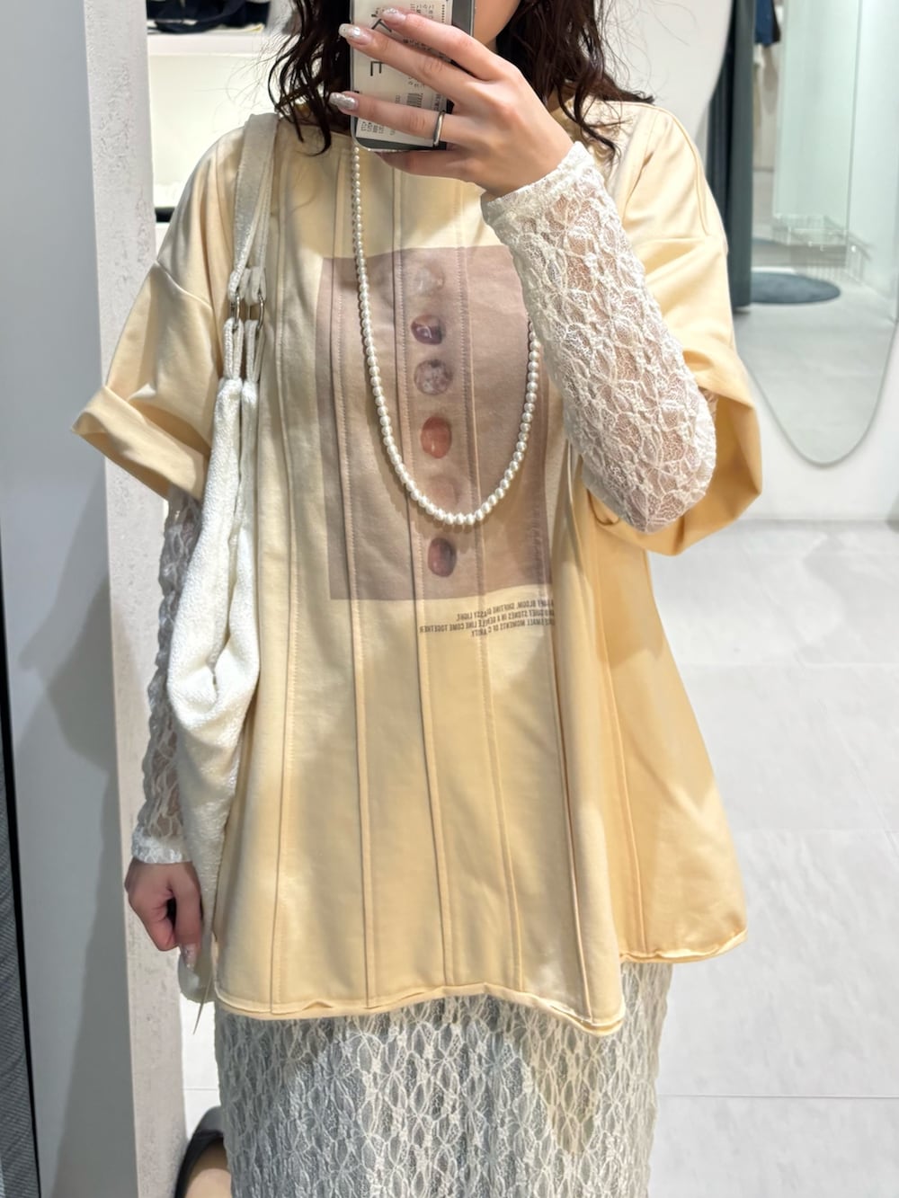 ブルー系のデニムパンツ、ホワイト系のワンピース、イエロー系のTシャツ/カットソーを着用したレディースの春コーディネートの7枚目の写真