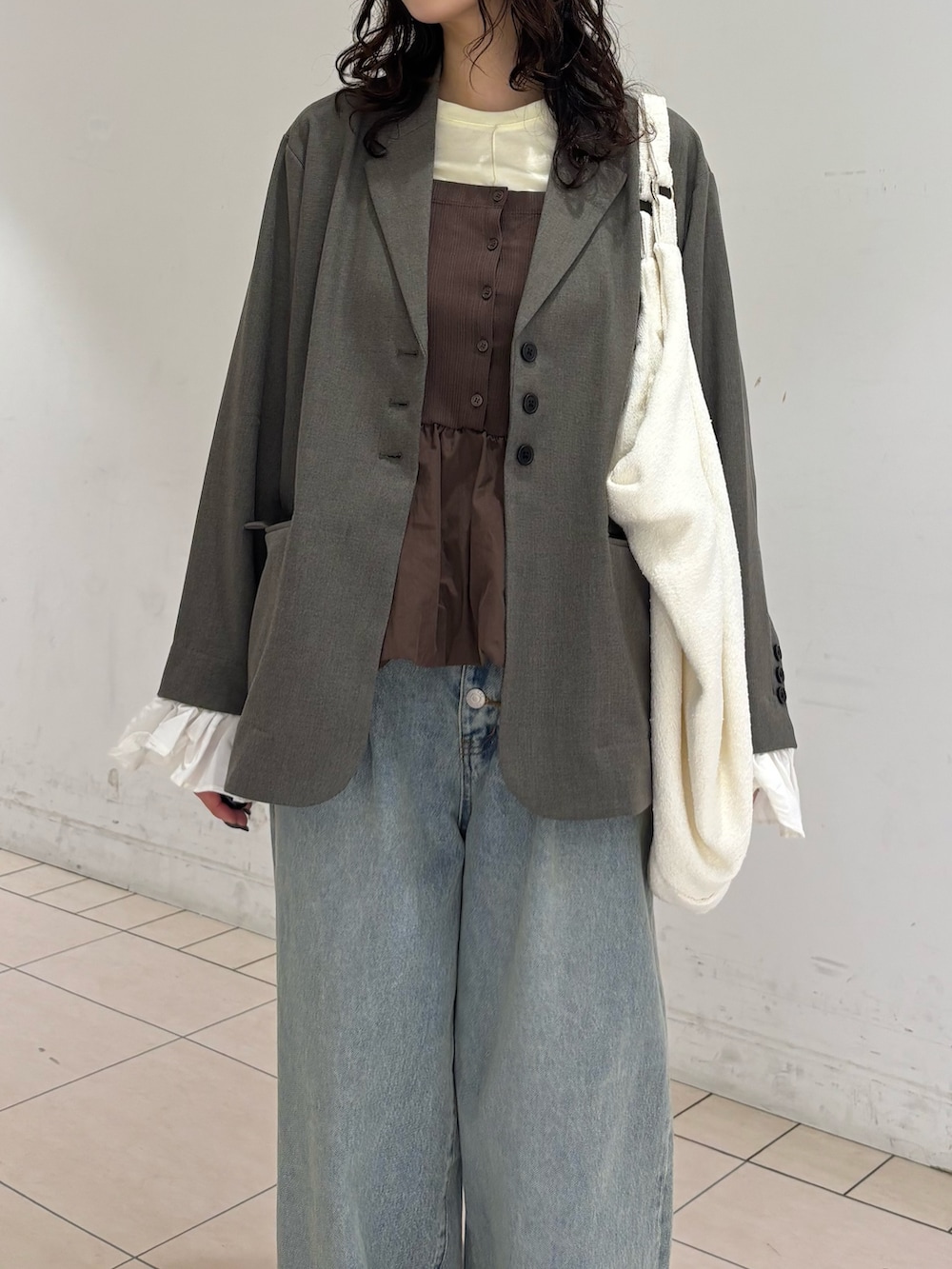 グレー系のその他アウター、イエロー系のTシャツ/カットソー、ブルー系のデニムパンツを着用したレディースの春コーディネートの5枚目の写真