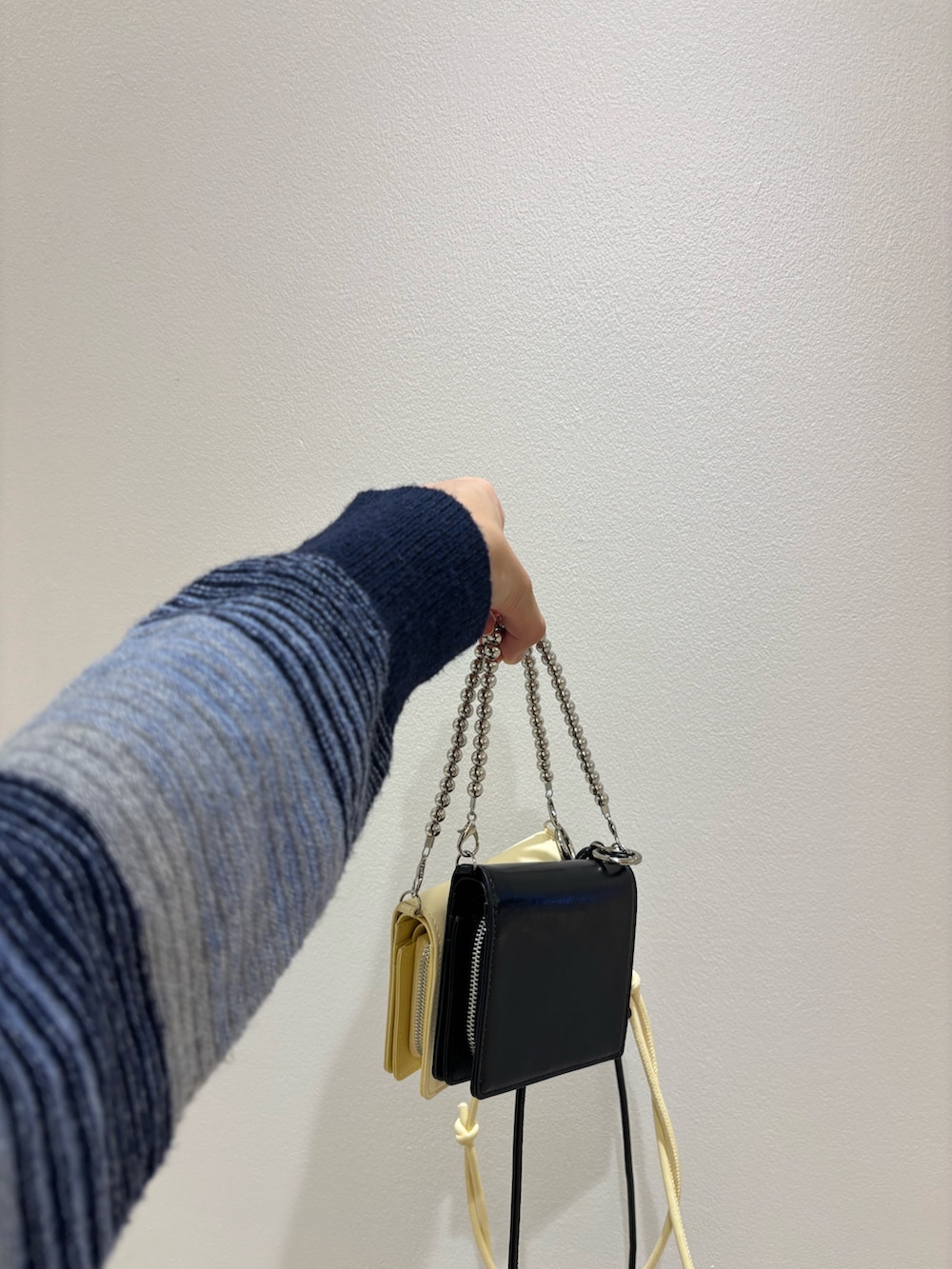 ベージュ系のその他パンツ、ブルー系のカーディガン/ボレロ、ブラック系の財布を着用したレディースの秋コーディネートの5枚目の写真