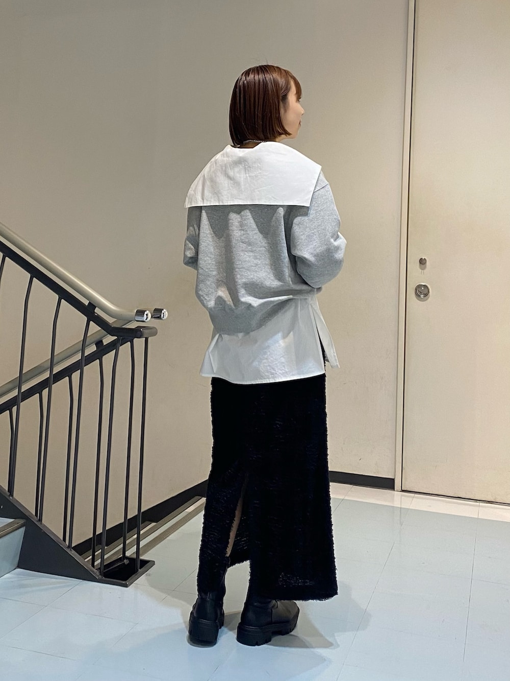 ホワイト系のシャツ/ブラウス、グレー系のスウェット、ブラック系のスカートを着用したレディースの冬コーディネートの3枚目の写真