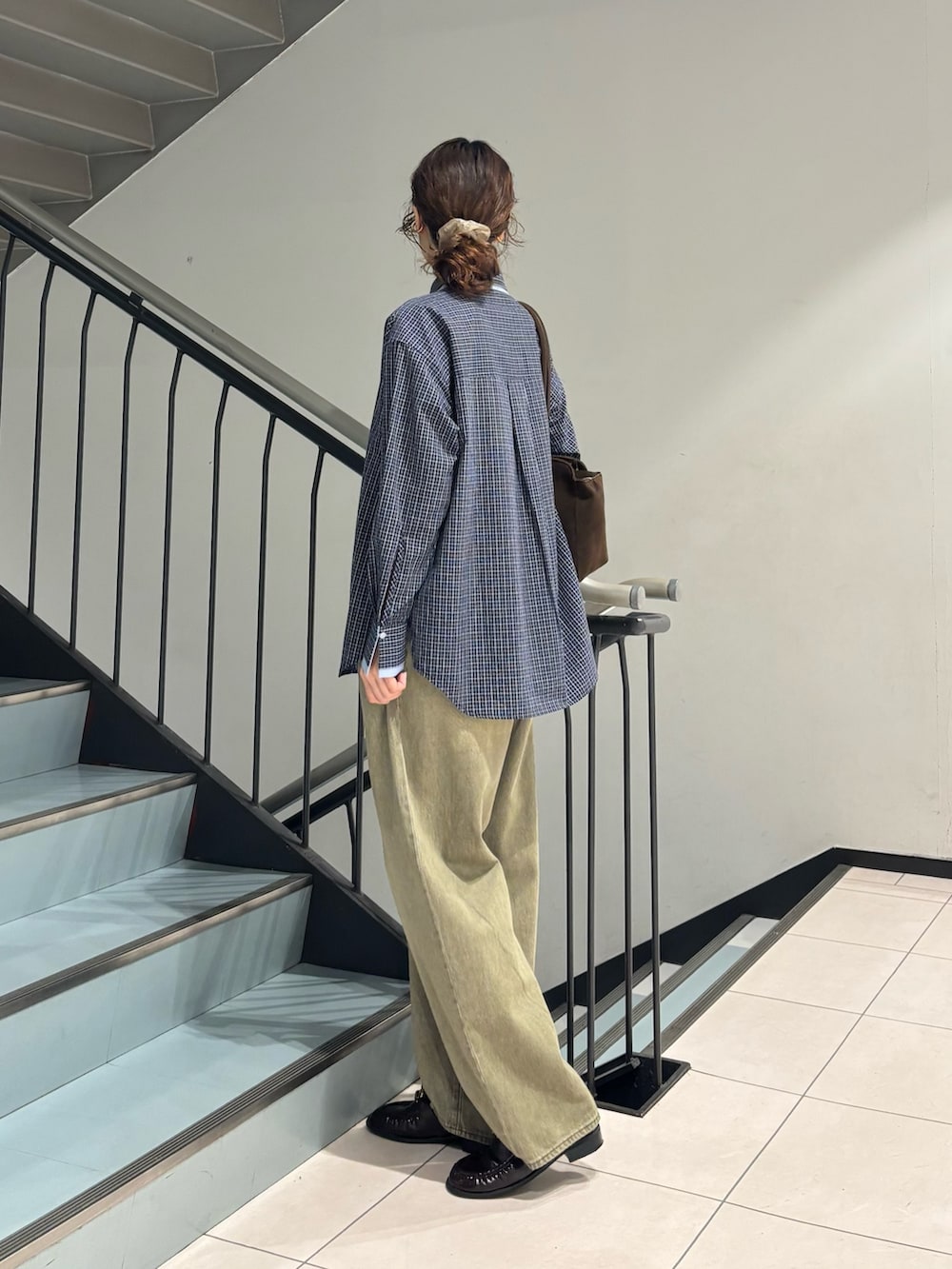 グリーン系のデニムパンツ、ブルー系のシャツ/ブラウス、ブラウン系のボストンバッグを着用したレディースの秋コーディネートの2枚目の写真