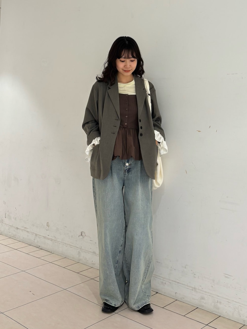 グレー系のその他アウター、イエロー系のTシャツ/カットソー、ブルー系のデニムパンツを着用したレディースの春コーディネートの2枚目の写真