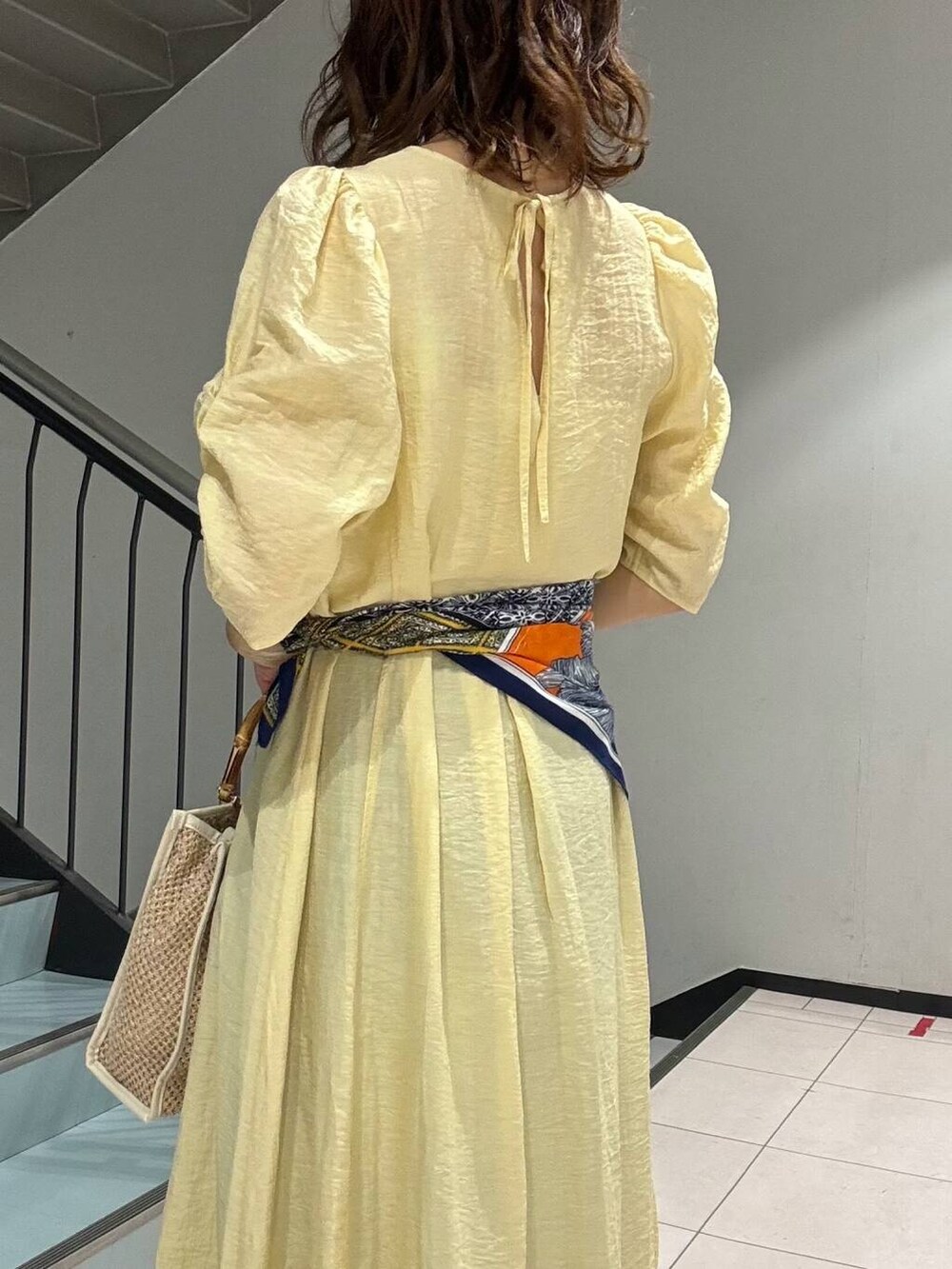 ブルー系のデニムパンツ、イエロー系のその他シューズ、ホワイト系のショルダーバッグを着用したレディースの春コーディネートの7枚目の写真