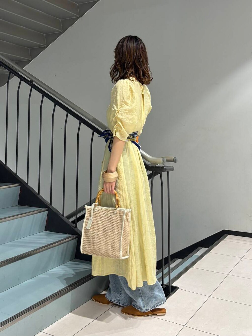 ブルー系のデニムパンツ、イエロー系のその他シューズ、ホワイト系のショルダーバッグを着用したレディースの春コーディネートの3枚目の写真