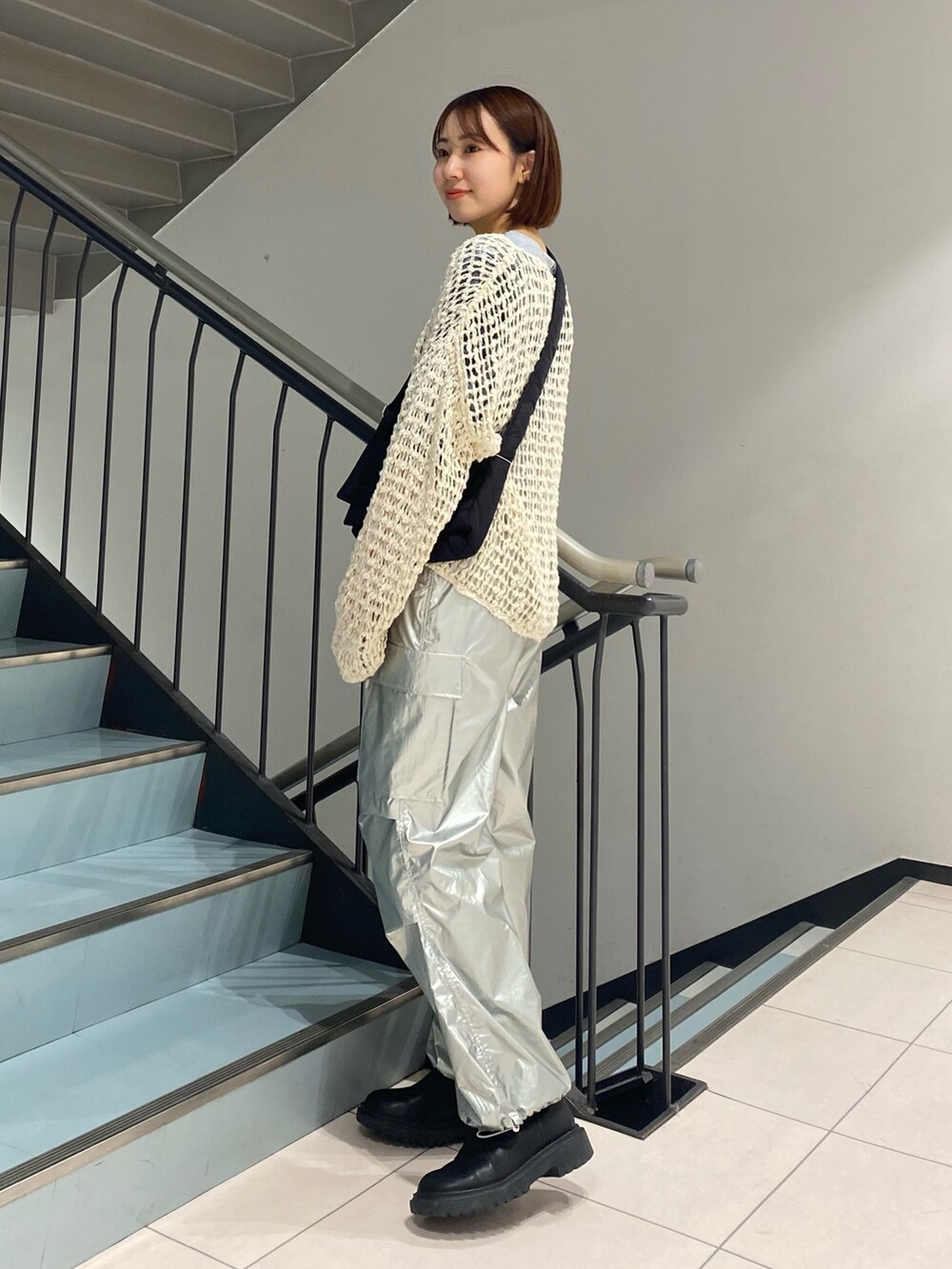 シルバー系のその他パンツ、グレー系のTシャツ/カットソー、ホワイト系のニット/セーターを着用したレディースの冬コーディネートの2枚目の写真