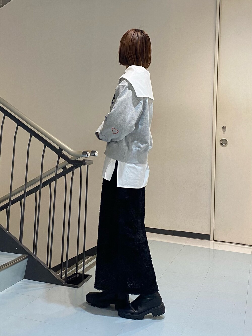 ホワイト系のシャツ/ブラウス、グレー系のスウェット、ブラック系のスカートを着用したレディースの冬コーディネートの2枚目の写真