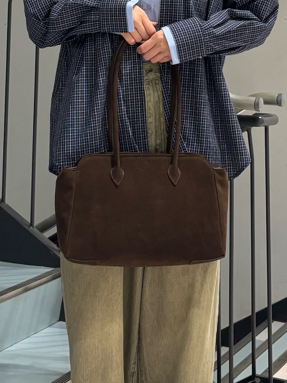 グリーン系のデニムパンツ、ブルー系のシャツ/ブラウス、ブラウン系のボストンバッグを着用したレディースの秋コーディネートの5枚目の写真