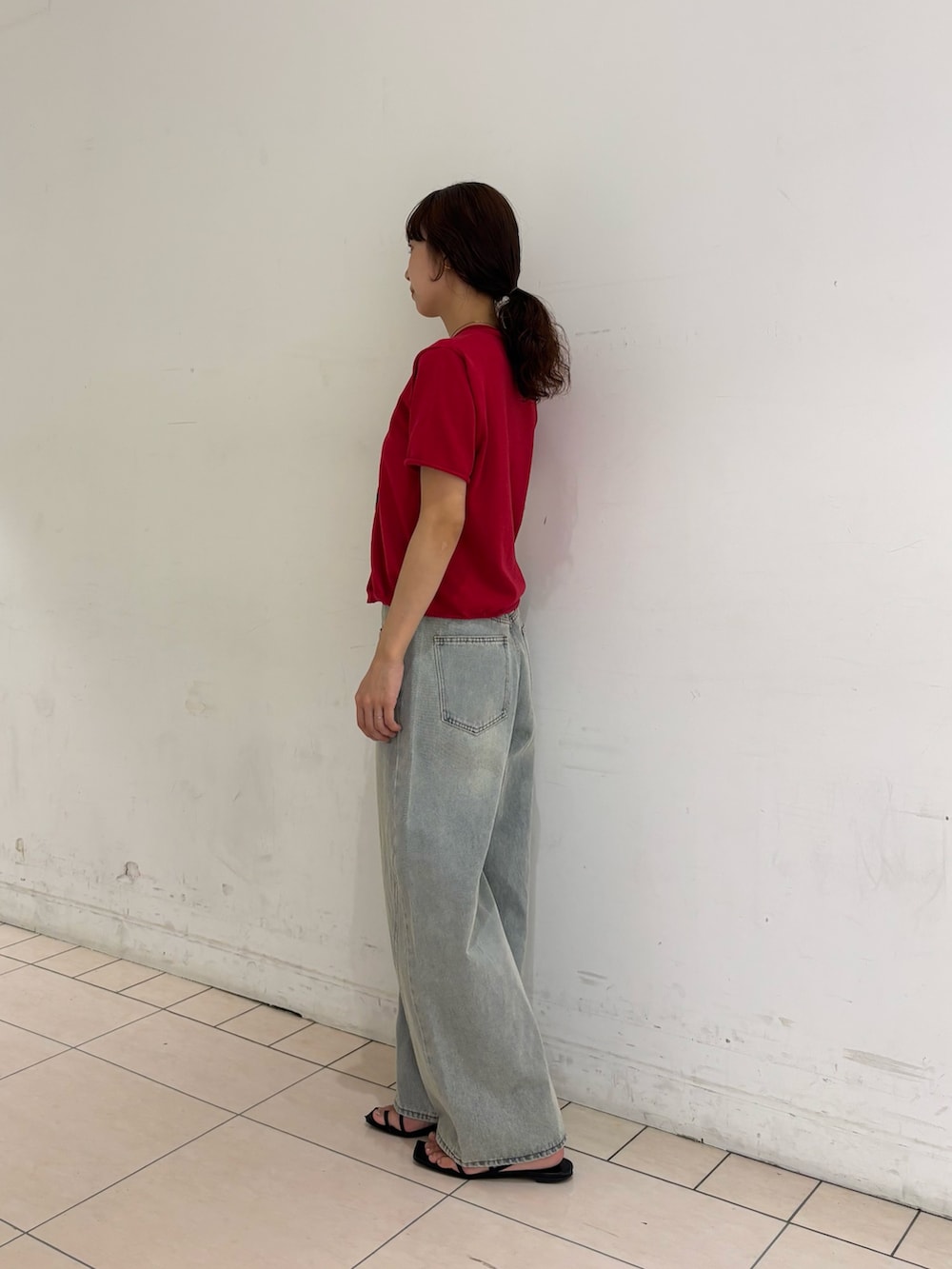 ブルー系のデニムパンツ、レッド系のカーディガン/ボレロ、ブラウン系のメガネを着用したレディースの夏コーディネートの2枚目の写真