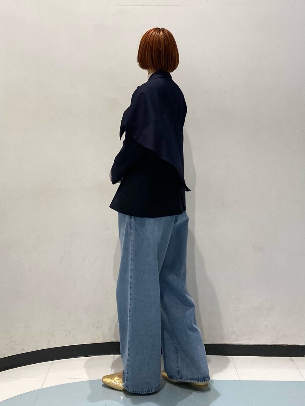 ブルー系のテーラードジャケット、ホワイト系のTシャツ/カットソー、ブルー系のデニムパンツを着用したレディースの冬コーディネートの2枚目の写真