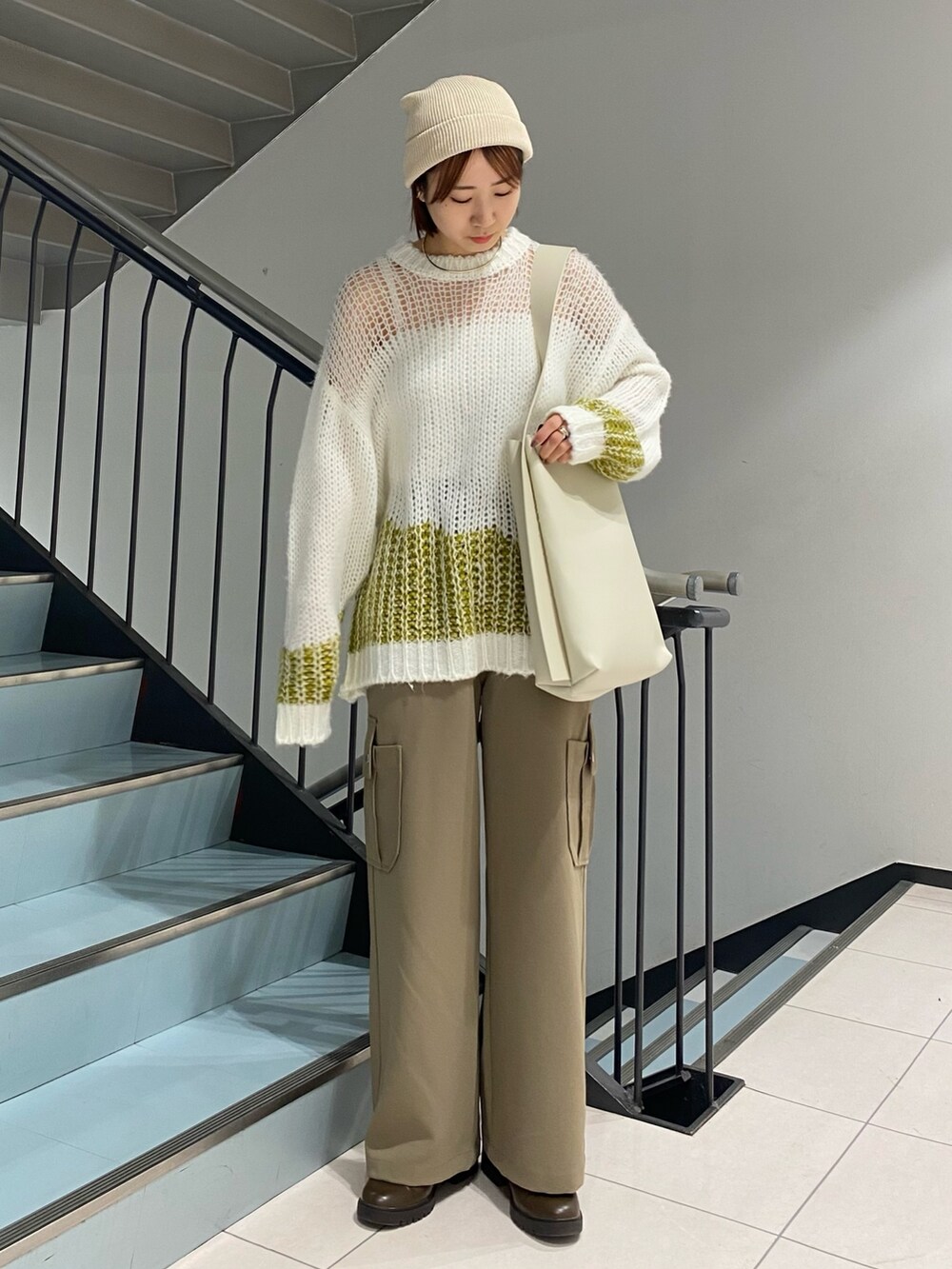 ホワイト系のショルダーバッグ、ホワイト系のニット/セーター、グリーン系のその他パンツを着用したレディースの冬コーディネートの2枚目の写真