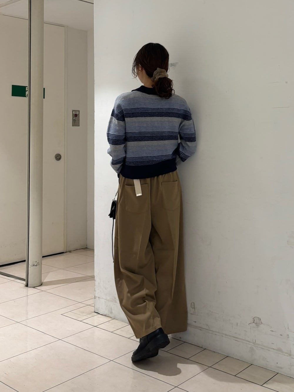 ベージュ系のその他パンツ、ブルー系のカーディガン/ボレロ、ブラック系の財布を着用したレディースの秋コーディネートの3枚目の写真