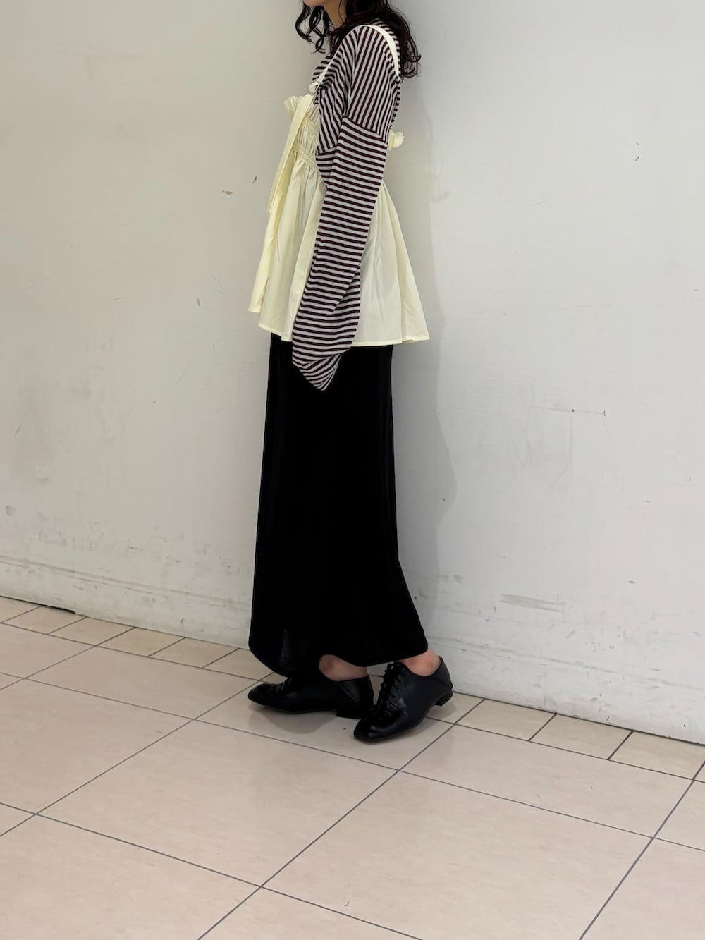 ブラック系のスカート、レッド系のニット/セーター、ホワイト系のその他トップスを着用したレディースの春コーディネートの3枚目の写真