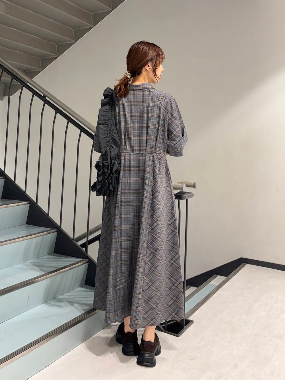 グレー系のショルダーバッグ、ブルー系のワンピース、ブラウン系のスニーカーを着用したレディースの夏コーディネートの3枚目の写真