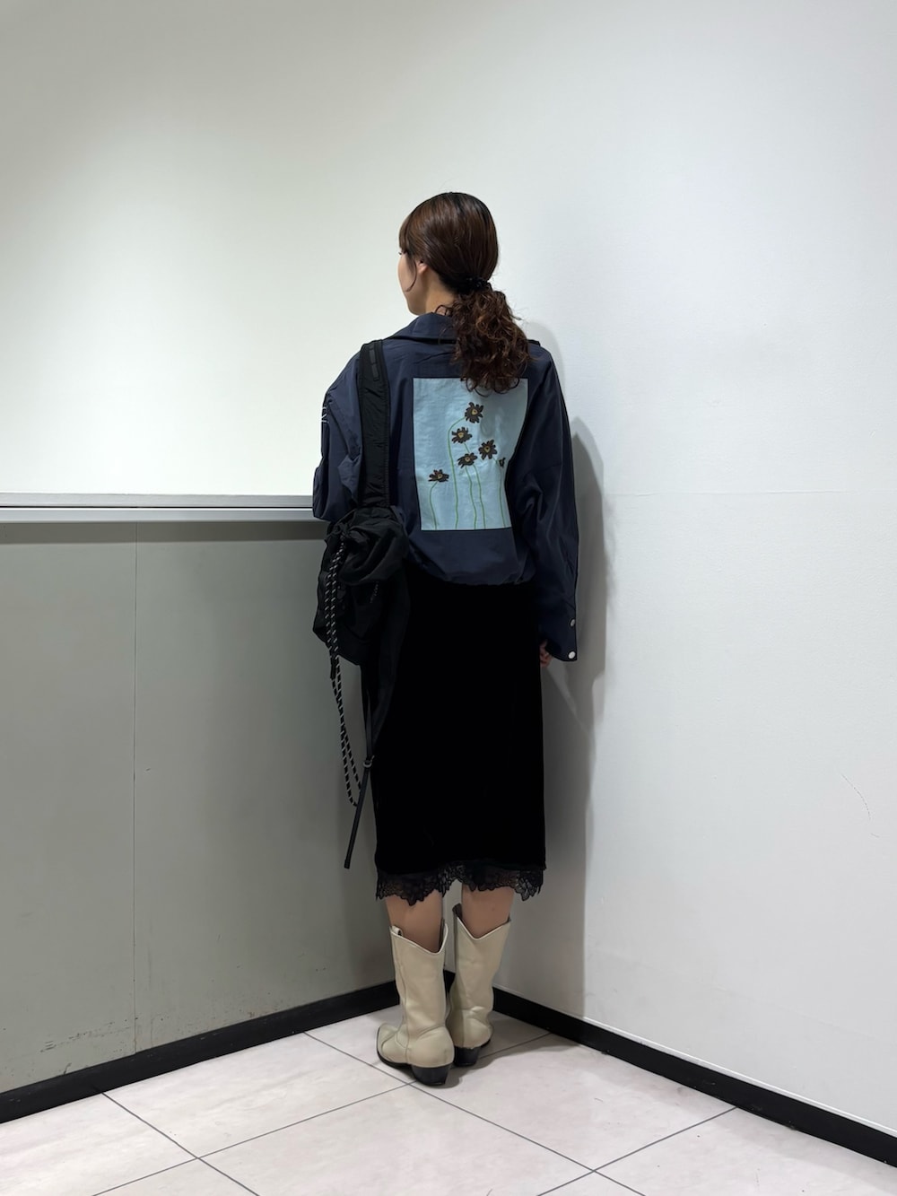 ブラック系のスカート、ブルー系のブルゾン、ブラック系のバックパック/リュックを着用したレディースの秋コーディネートの3枚目の写真