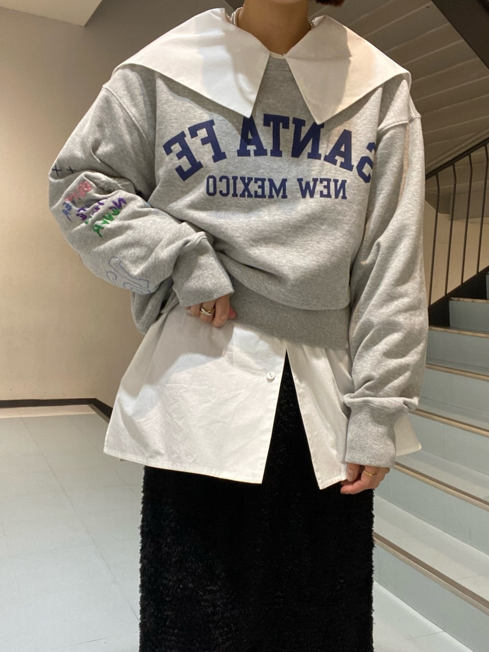 ホワイト系のシャツ/ブラウス、グレー系のスウェット、ブラック系のスカートを着用したレディースの冬コーディネートの4枚目の写真