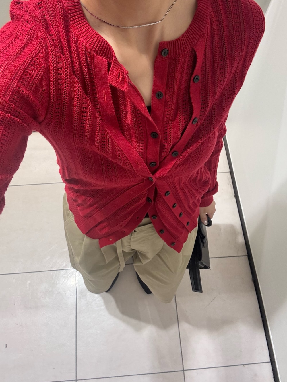 ベージュ系のその他パンツ、レッド系のニット/セーター、ブラック系のボストンバッグを着用したレディースの春コーディネートの4枚目の写真