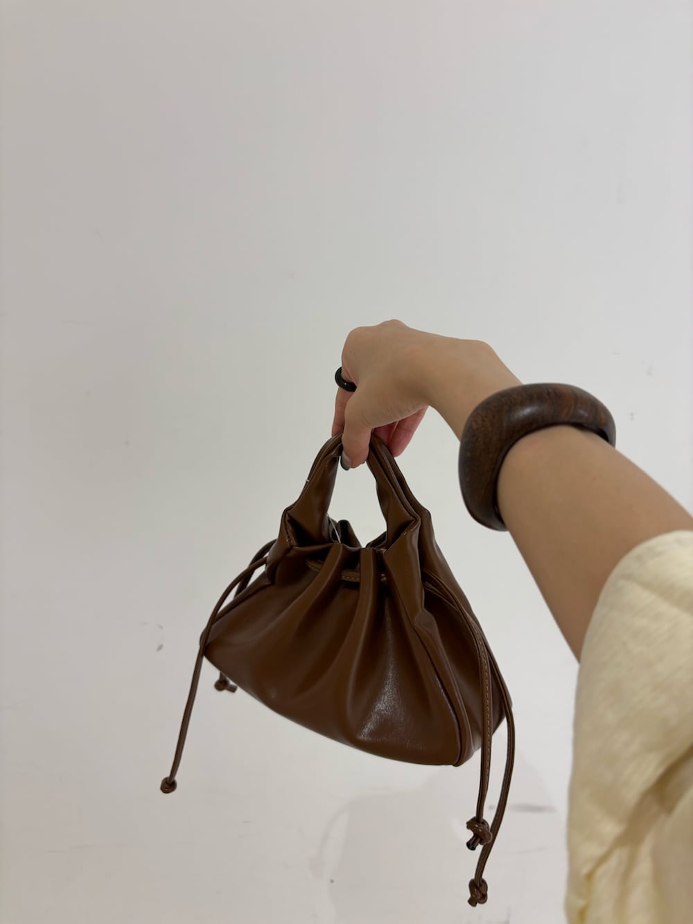 ホワイト系のスカート、ホワイト系のシャツ/ブラウス、ブラウン系のハンドバッグを着用したレディースの夏コーディネートの6枚目の写真