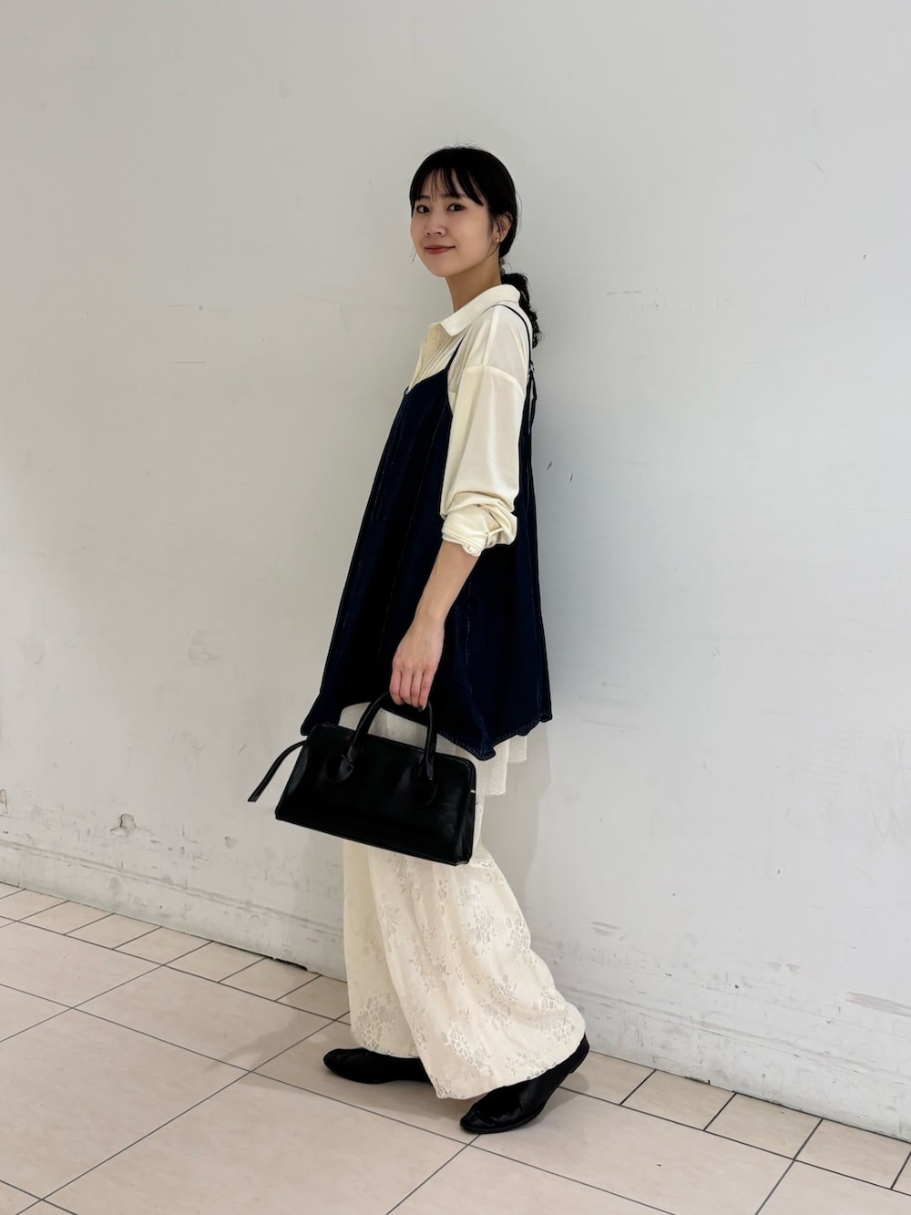 ブルー系のワンピース、ホワイト系のシャツ/ブラウス、ブラック系のボストンバッグを着用したレディースの冬コーディネートの2枚目の写真