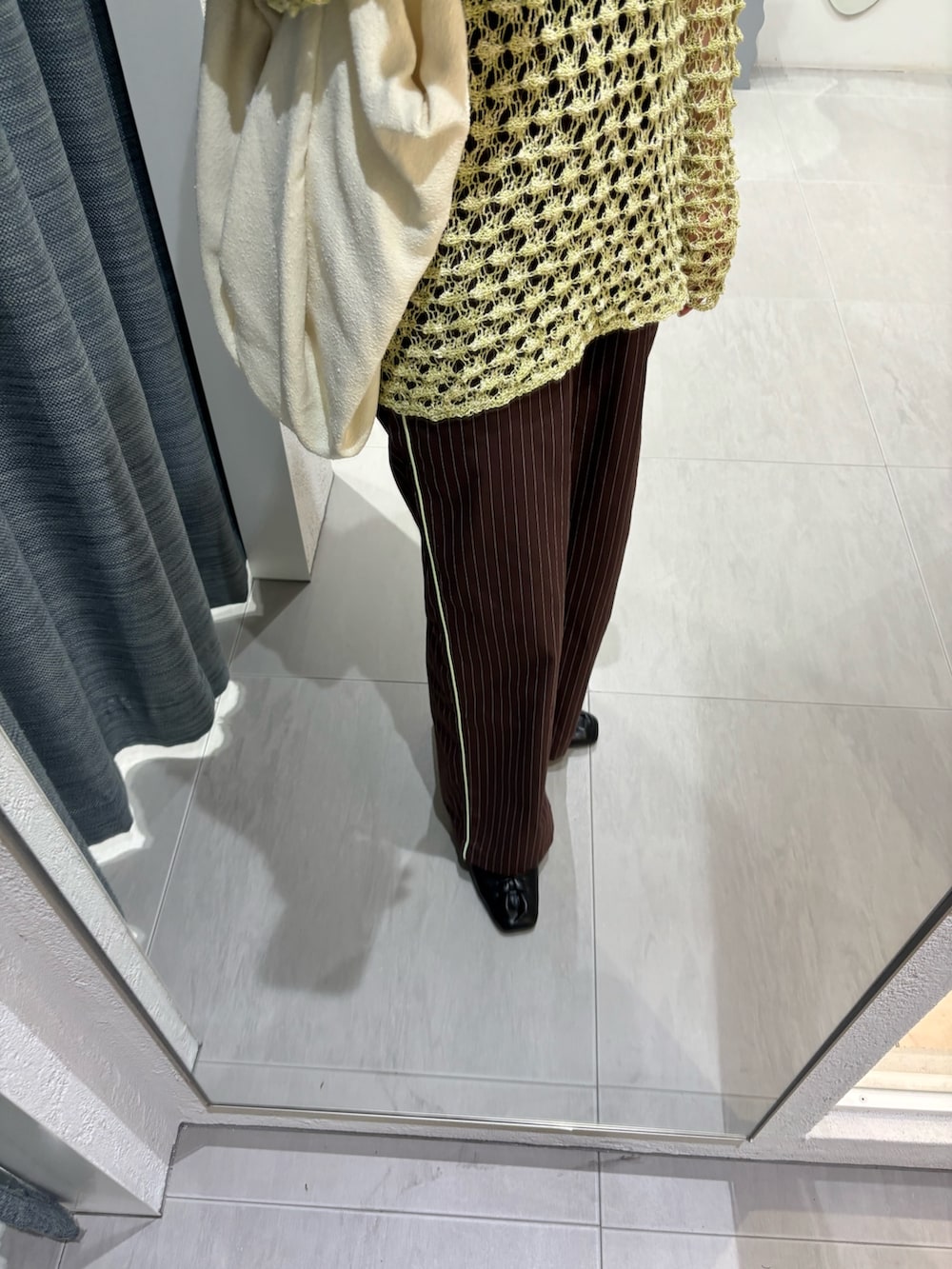 ブラウン系のその他パンツ、グリーン系のニット/セーター、ホワイト系のトートバッグを着用したレディースの春コーディネートの6枚目の写真