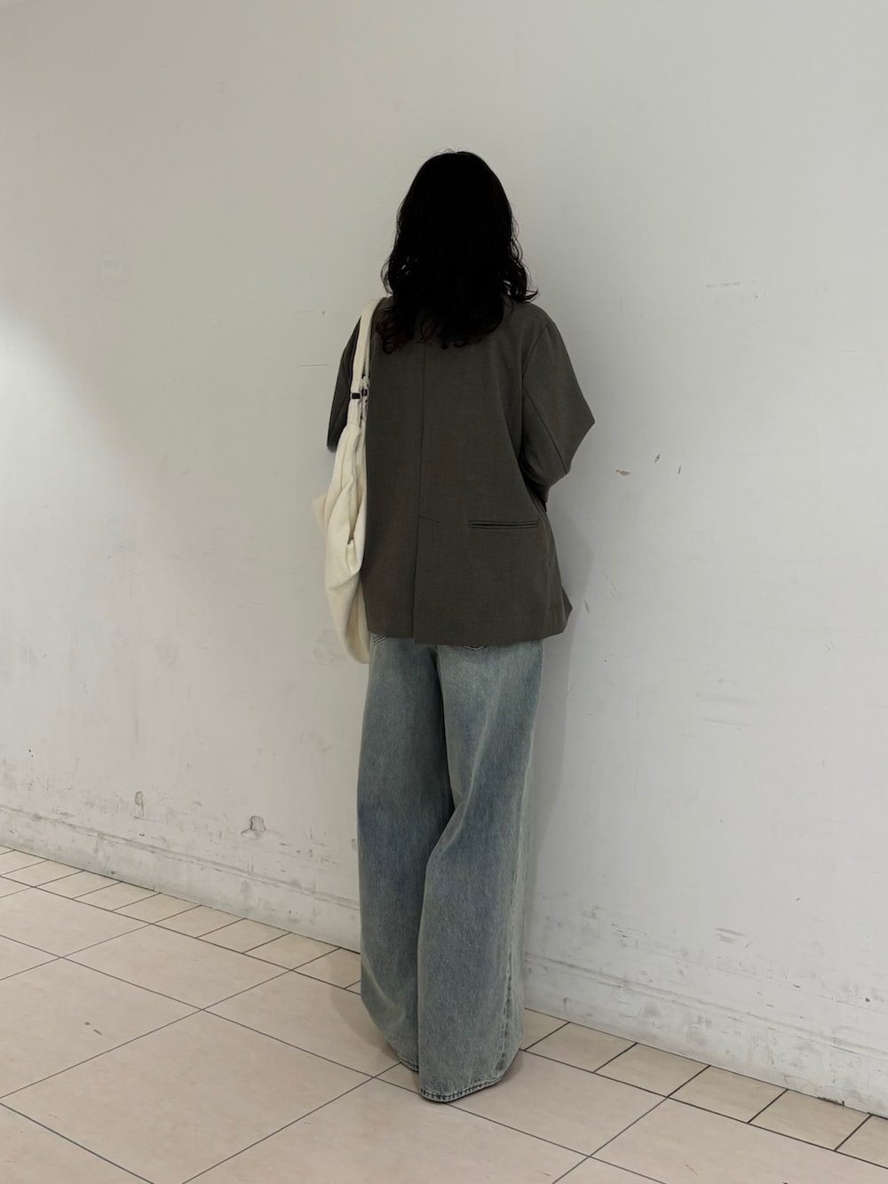 グレー系のその他アウター、イエロー系のTシャツ/カットソー、ブルー系のデニムパンツを着用したレディースの春コーディネートの4枚目の写真