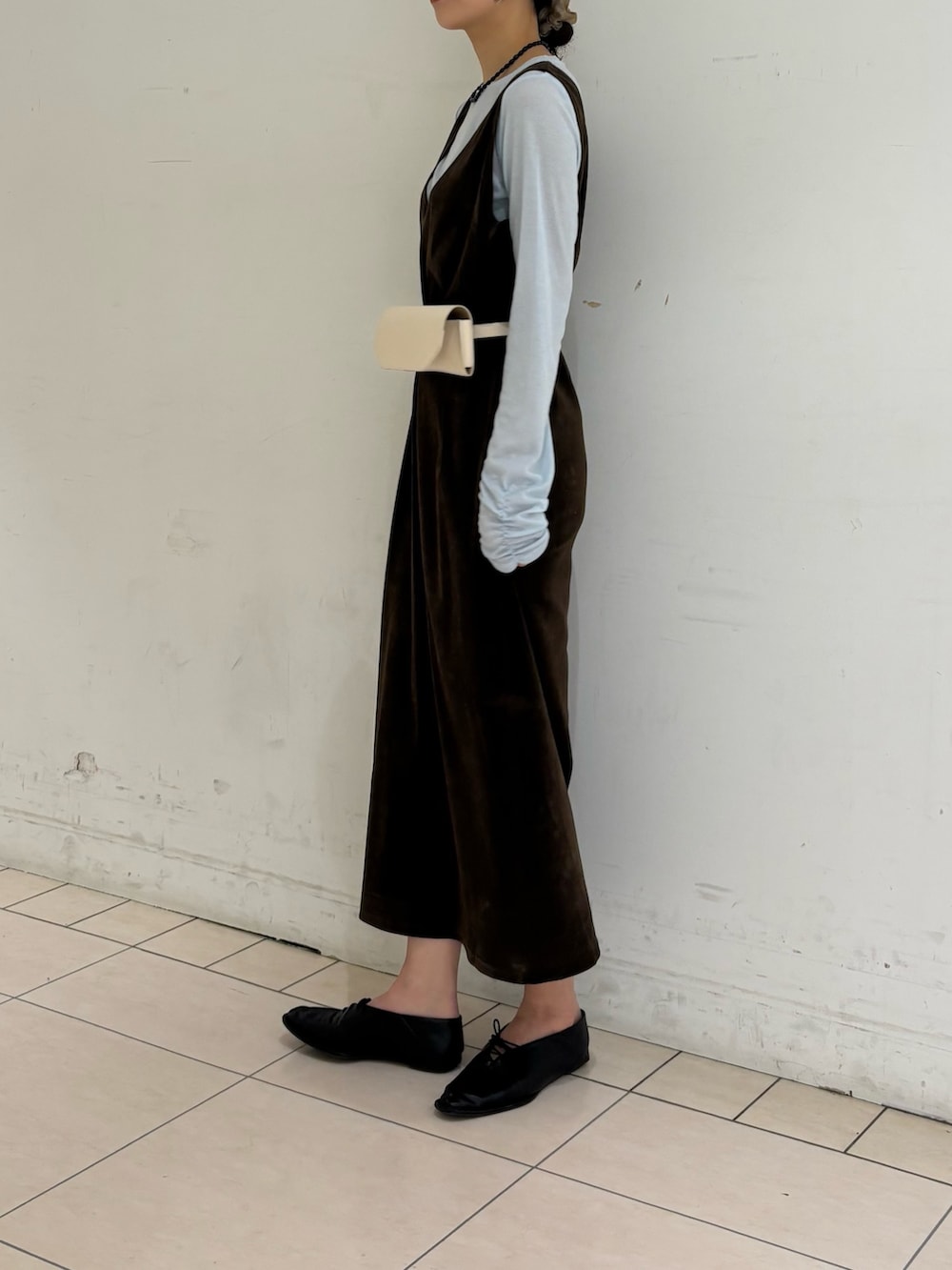 ブラウン系のワンピース、グレー系のTシャツ/カットソー、ホワイト系のボディバッグ/ウエストポーチを着用したレディースの春コーディネートの2枚目の写真